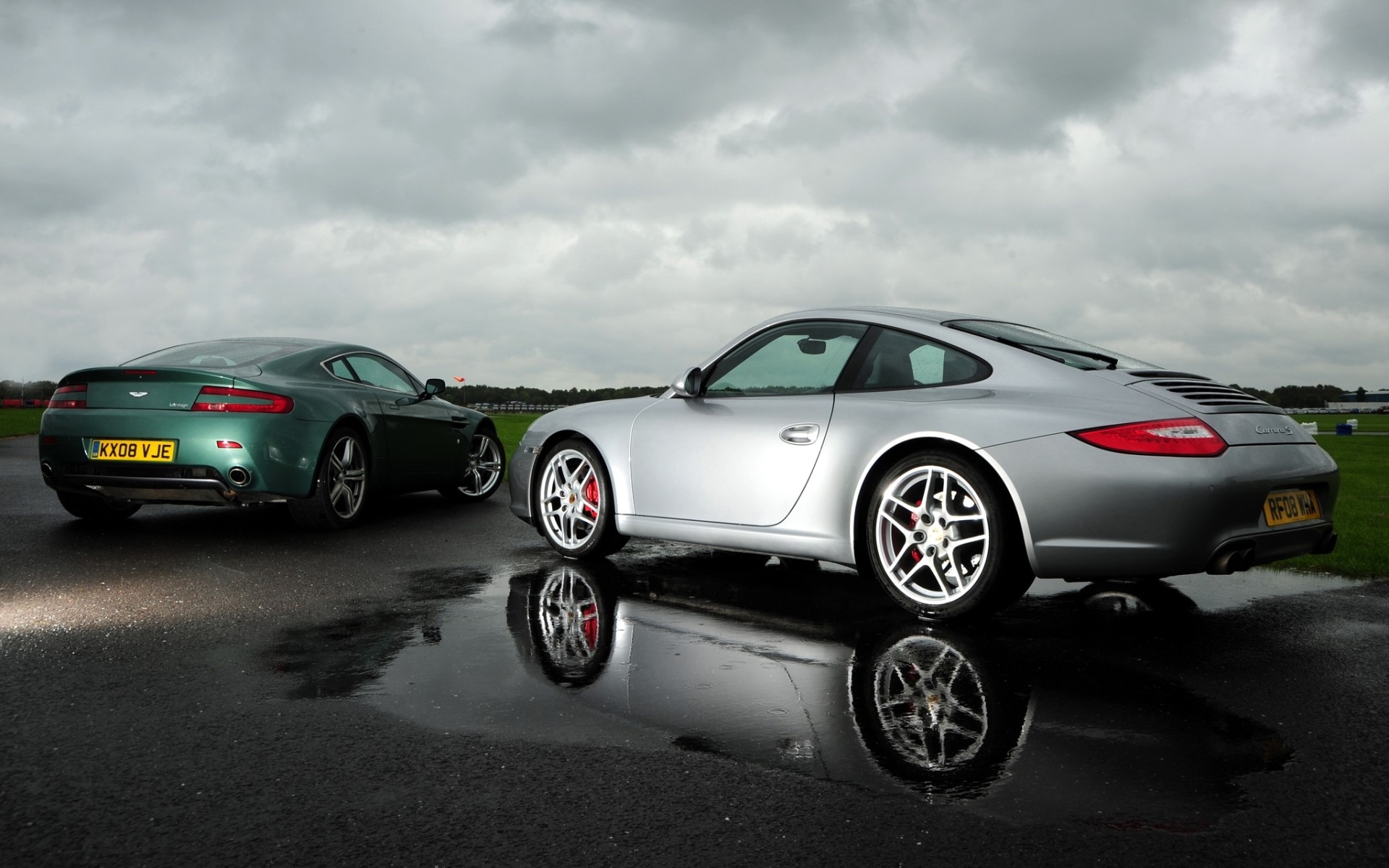 Aston Martin V8 Vantage and Porsche 911 on wet asphalt HD Wallpaper