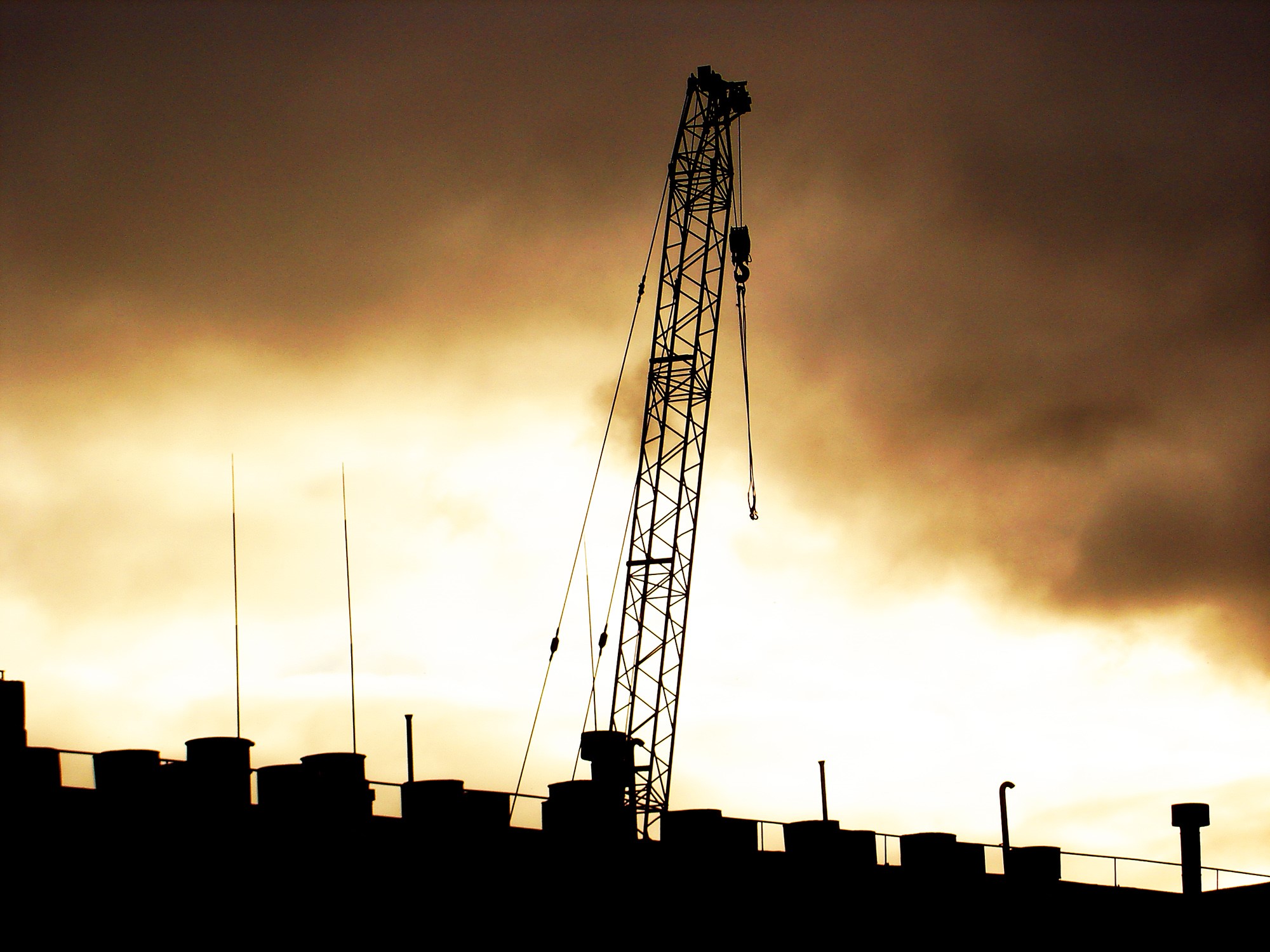 Silhouette of a crane against a cloudy sky HD Wallpaper