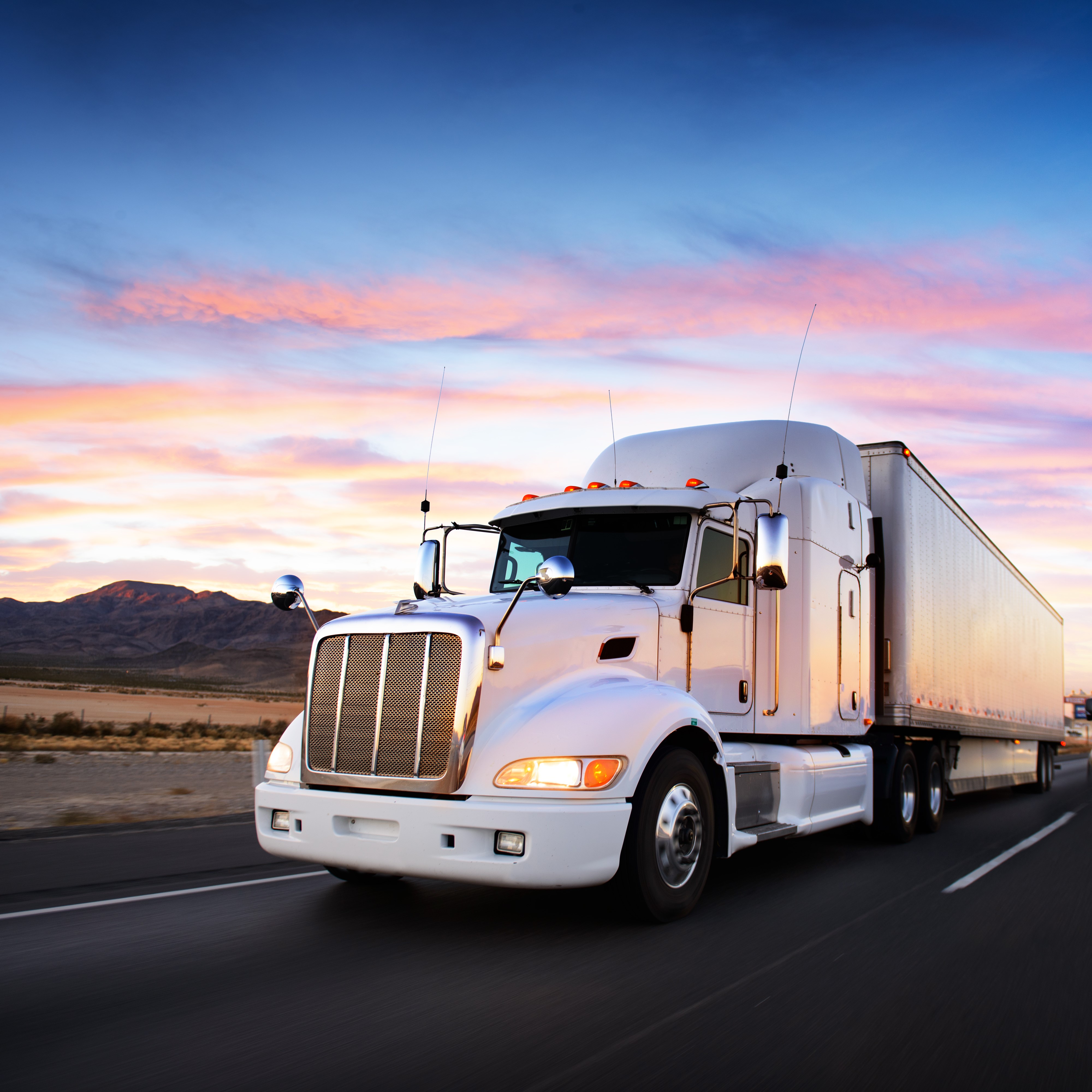 White semi-truck driving on highway at sunset HD Wallpaper