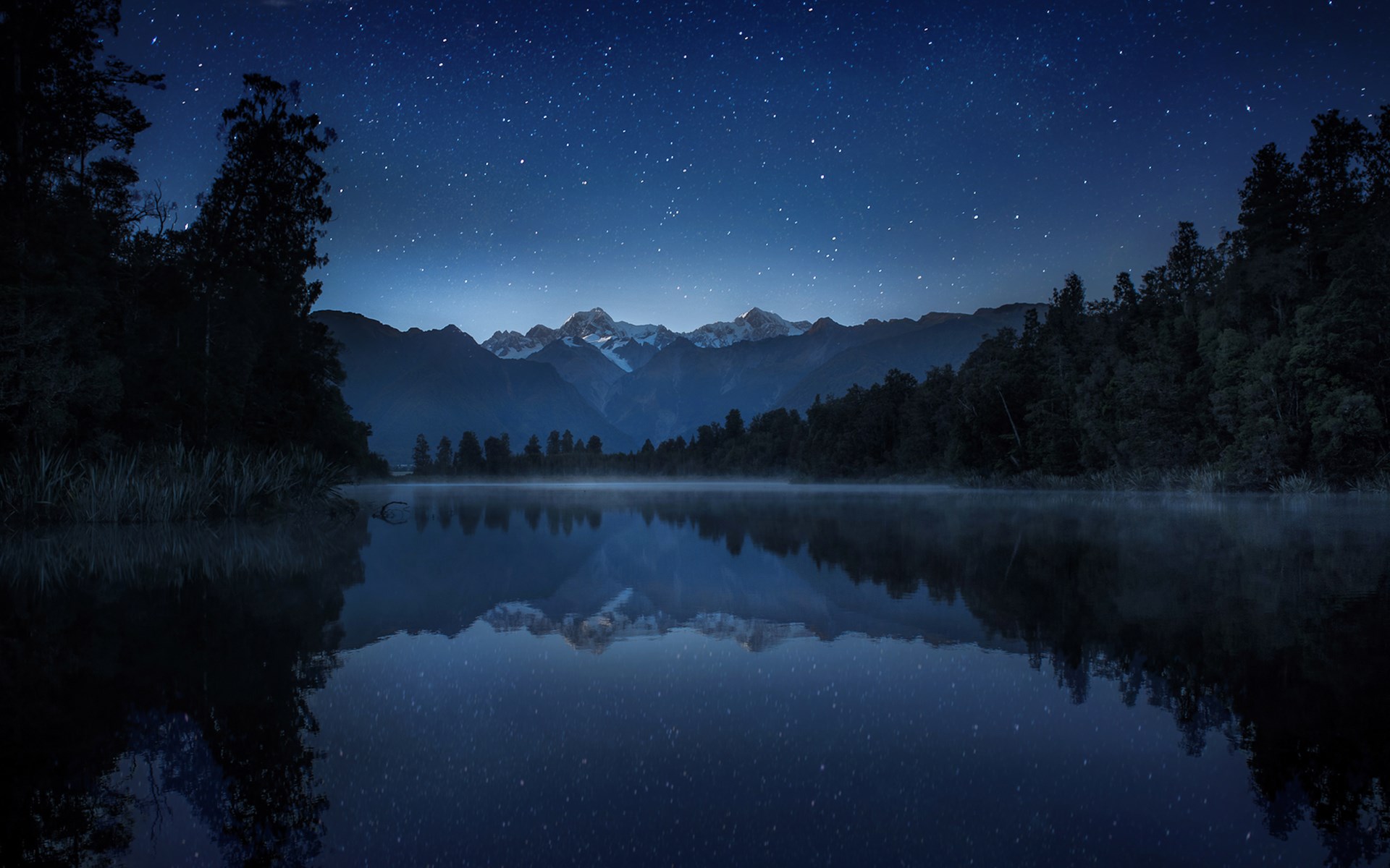Starry night over a misty lake and mountains HD Wallpaper