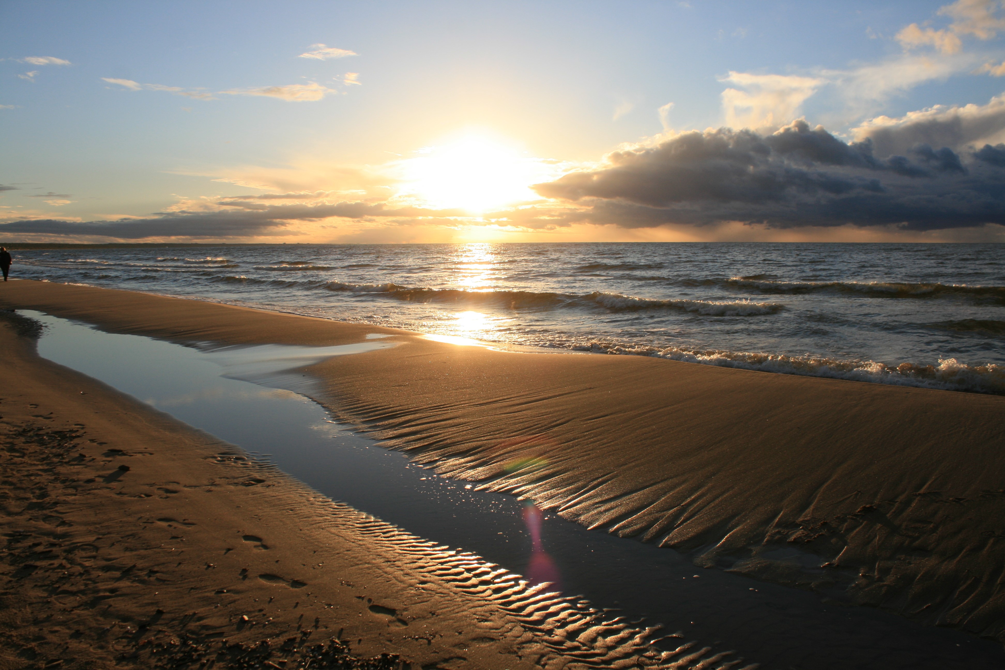 Beach at sunset with calm sea and clouds HD Wallpaper