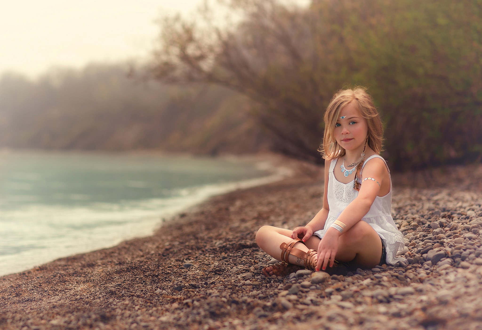 Girl sitting on a rocky beach HD Wallpaper