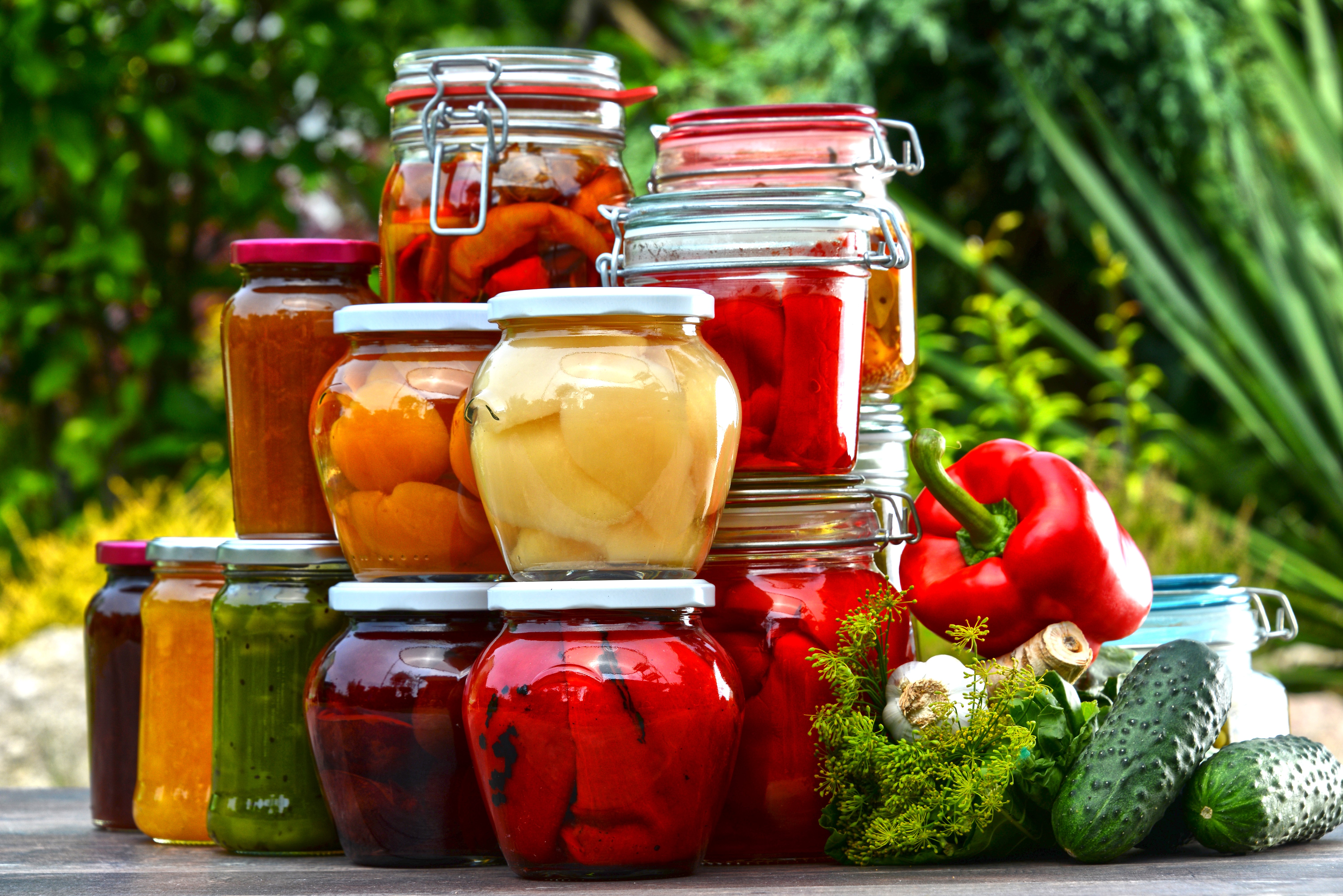 Jars of preserved vegetables and fruits with fresh produce HD Wallpaper