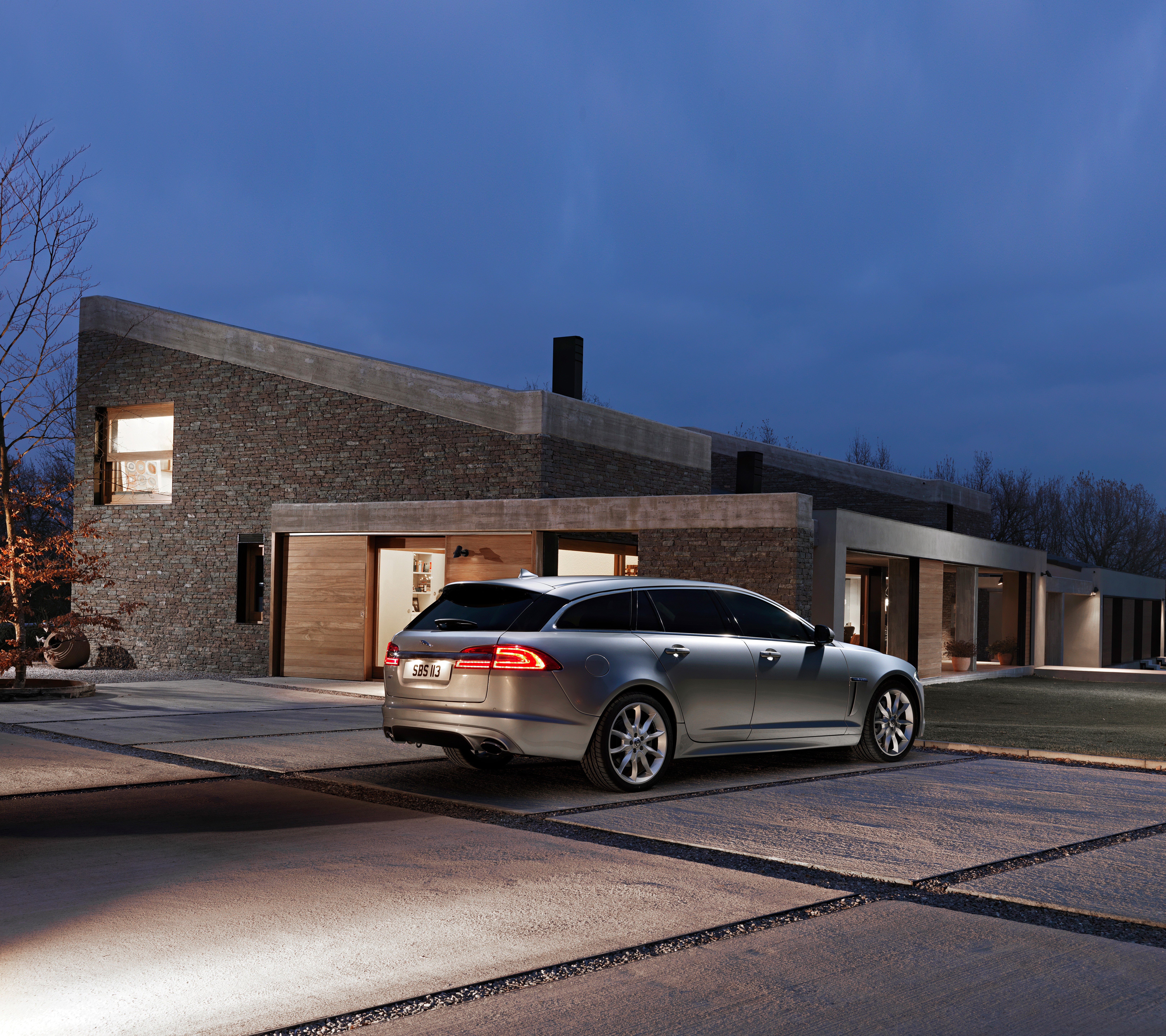 Jaguar XF Sportbrake parked in front of modern house HD Wallpaper