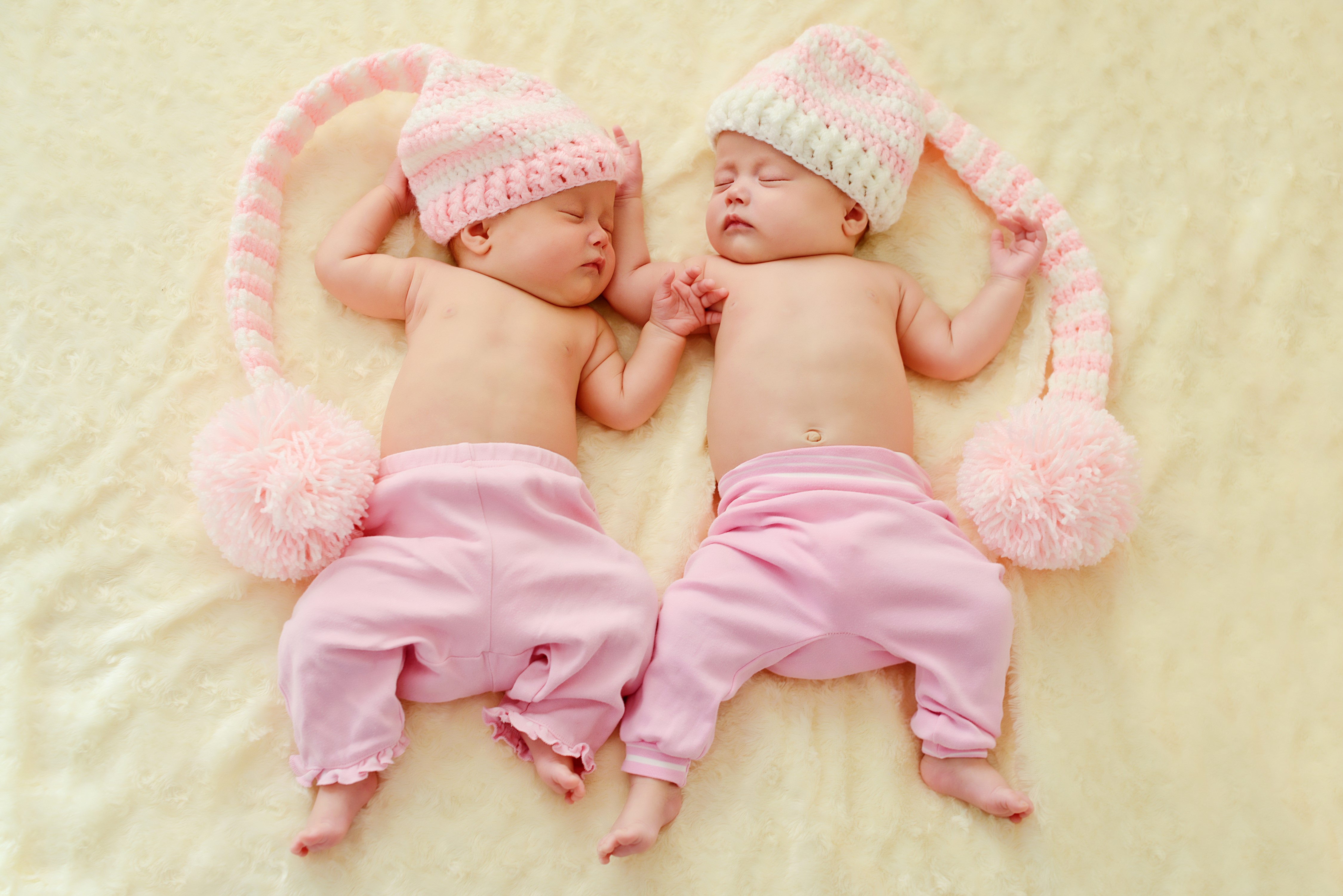 Two infants sleeping in winter hats HD Wallpaper