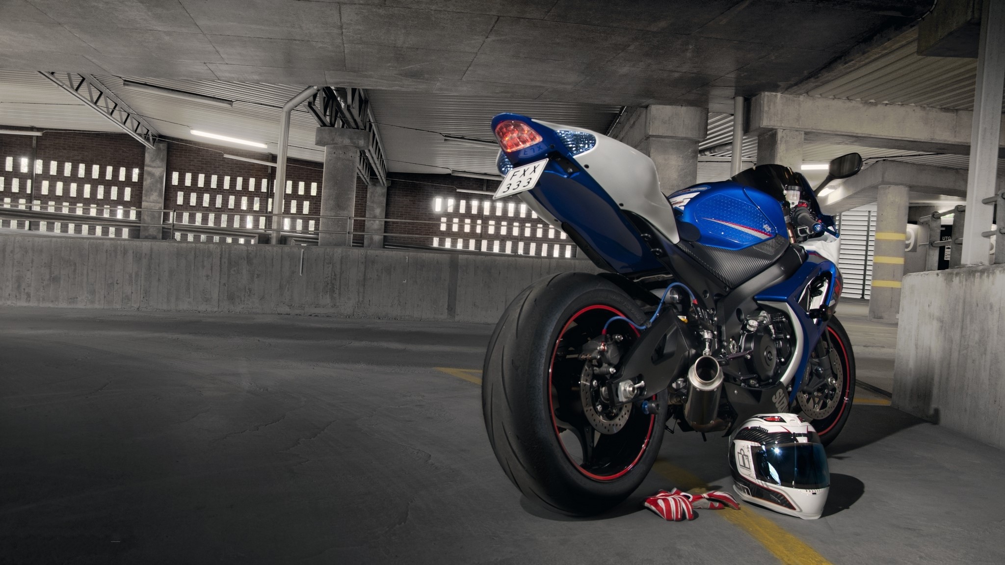 Blue and white Suzuki GSX-R1000 motorcycle with helmet in parking garage HD Wallpaper