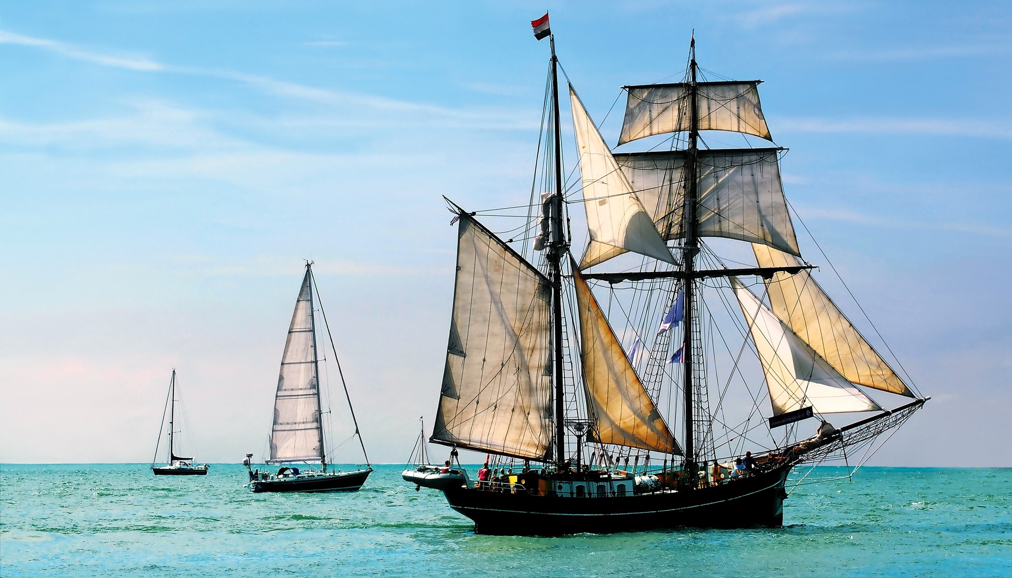 Sailing ships on the ocean under a blue sky HD Wallpaper