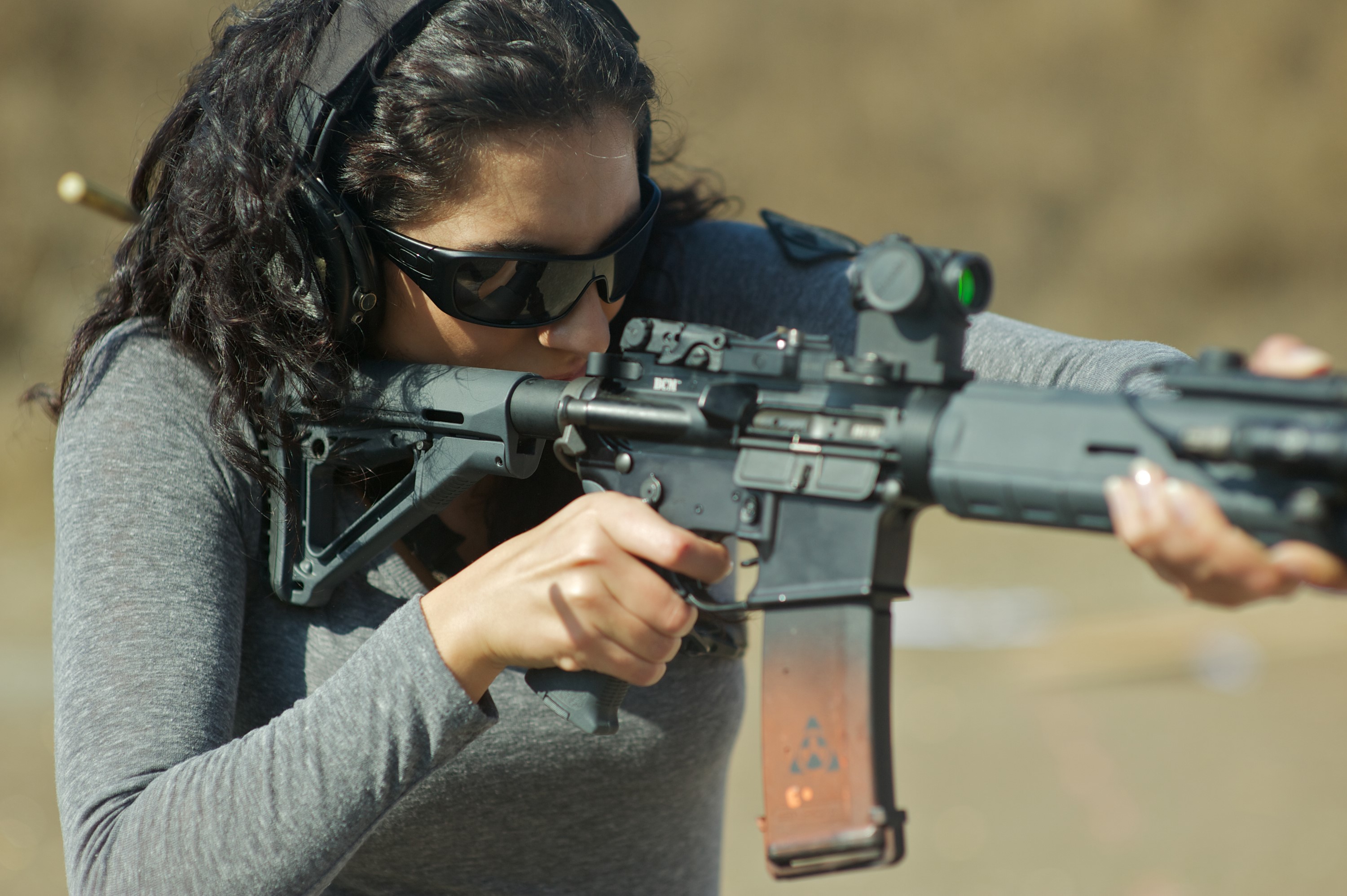 Woman aiming an assault rifle with red dot sight HD Wallpaper