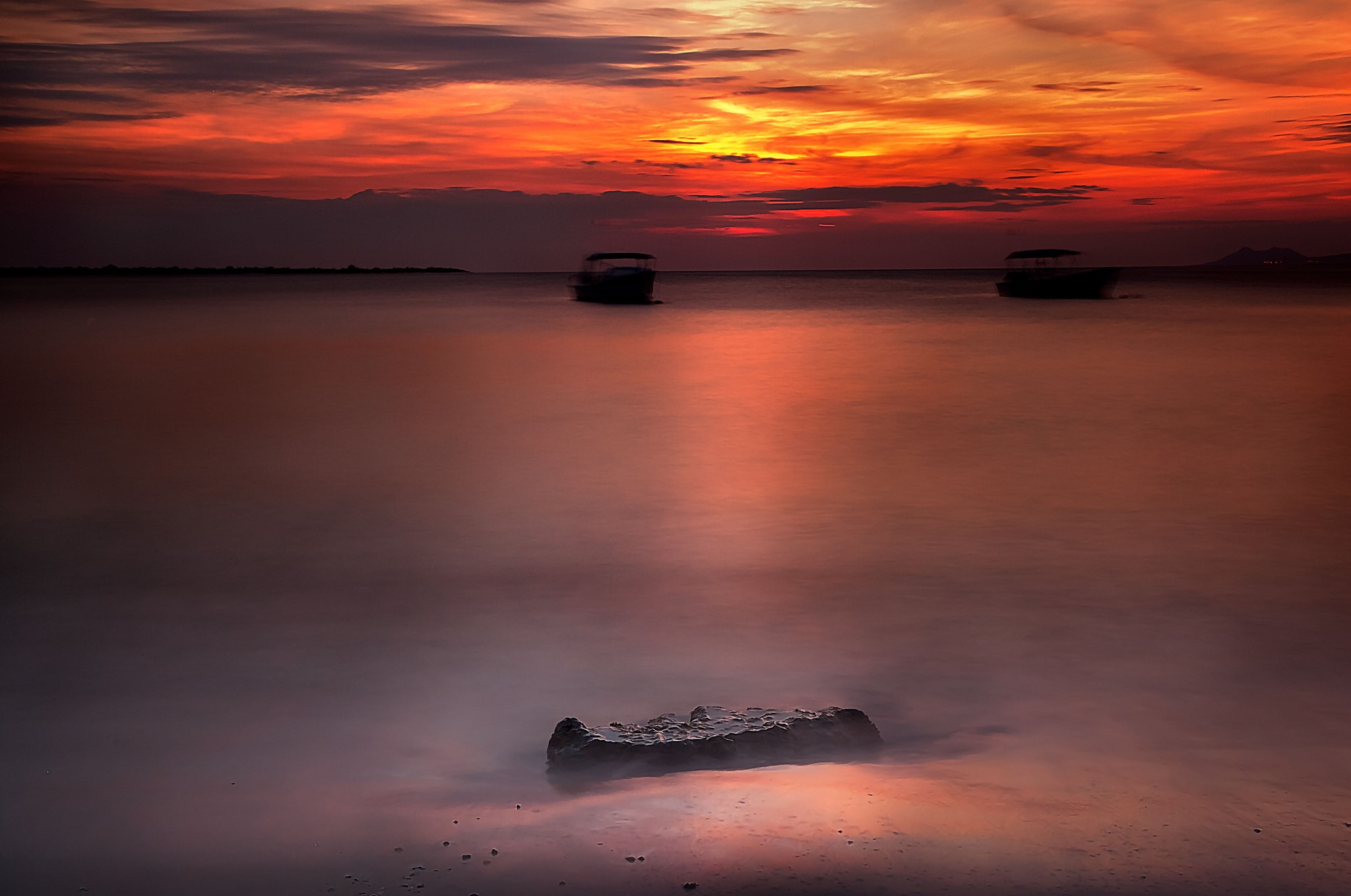 Sunset over the sea with boats and a rock HD Wallpaper