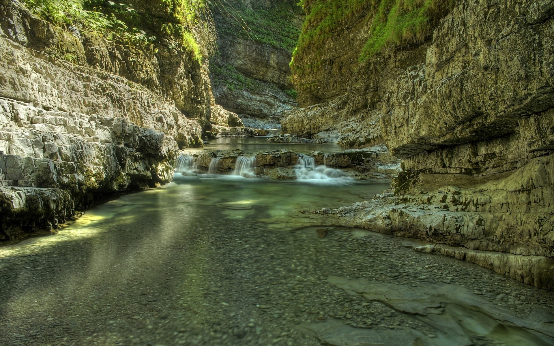 River flowing through a rocky gorge with waterfalls HD Wallpaper