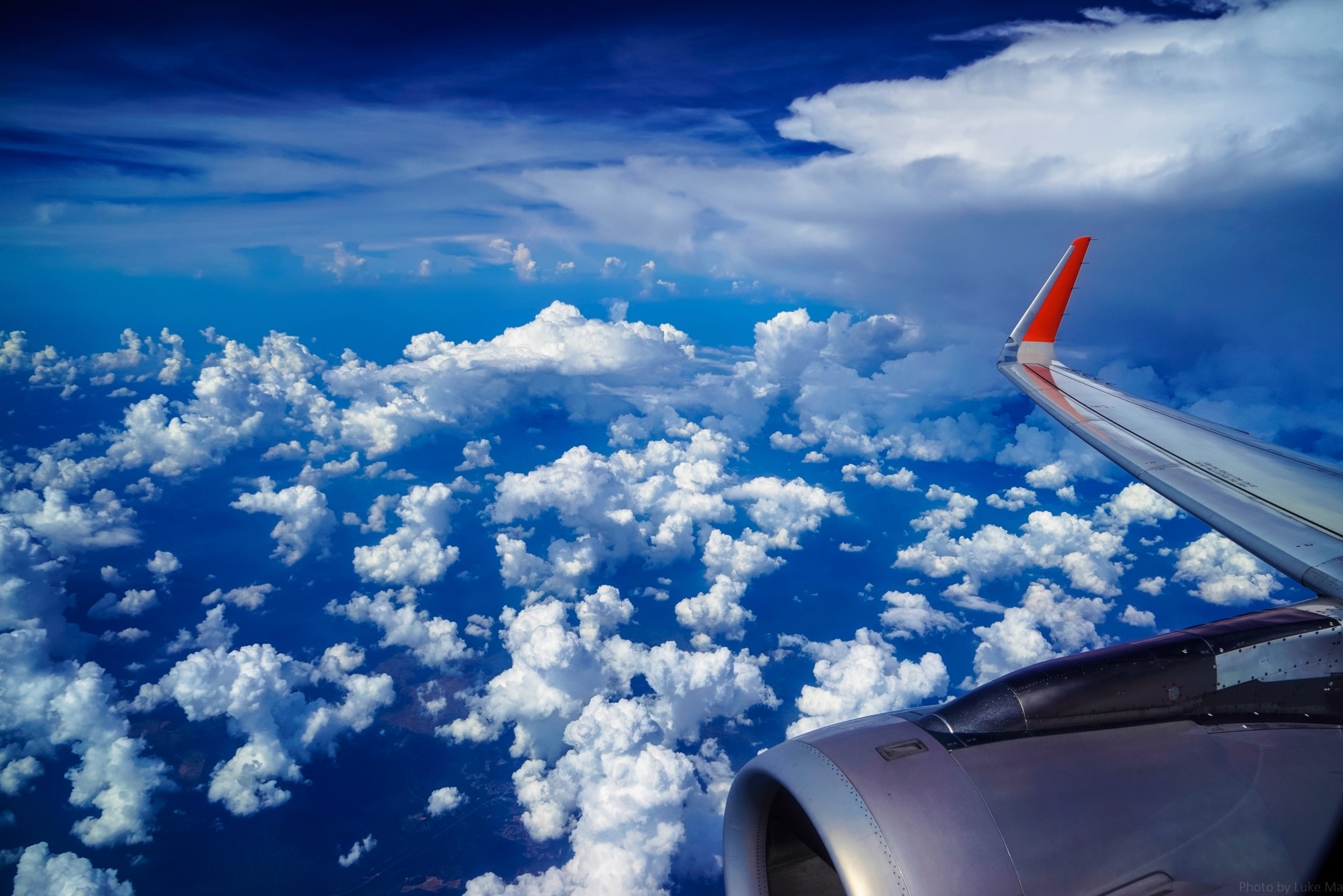 Airplane wing and engine flying over clouds HD Wallpaper