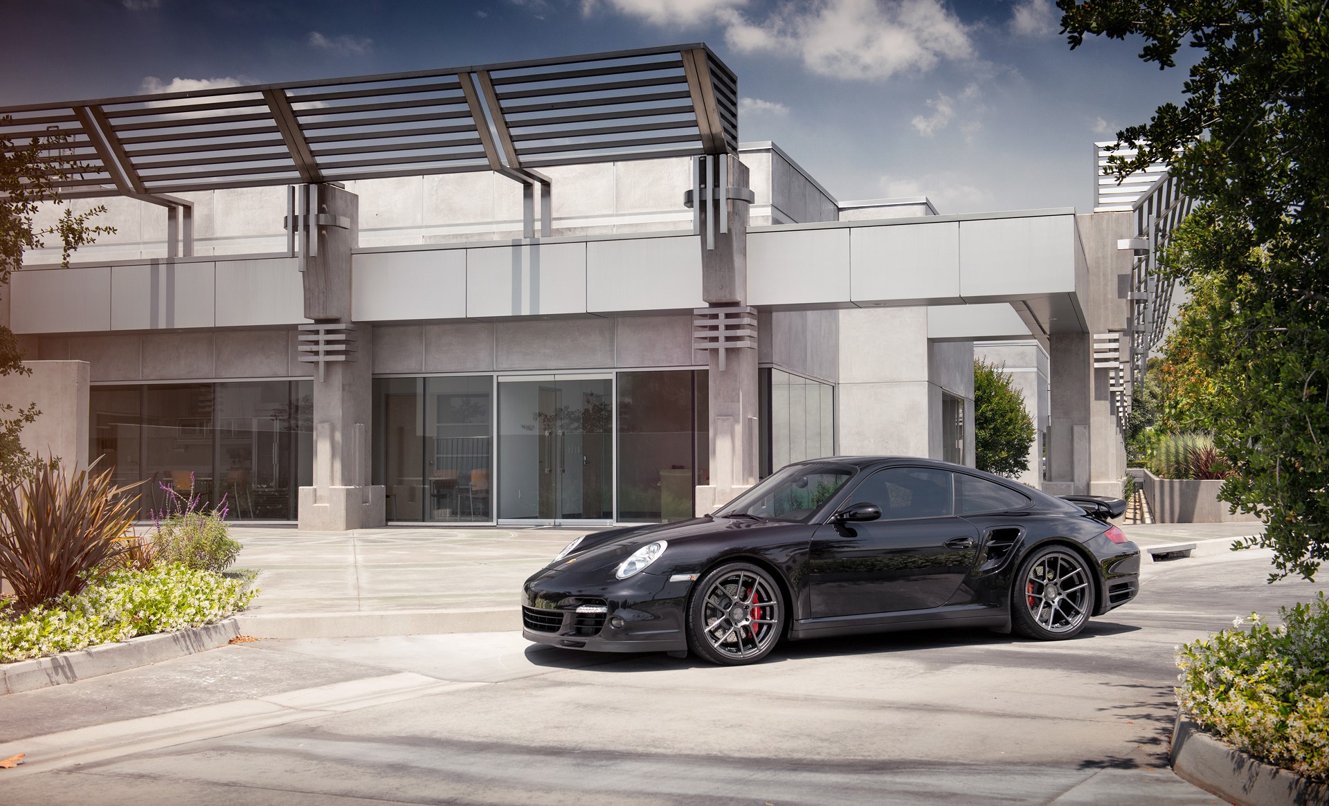 Black Porsche 997 Turbo parked outside modern building HD Wallpaper