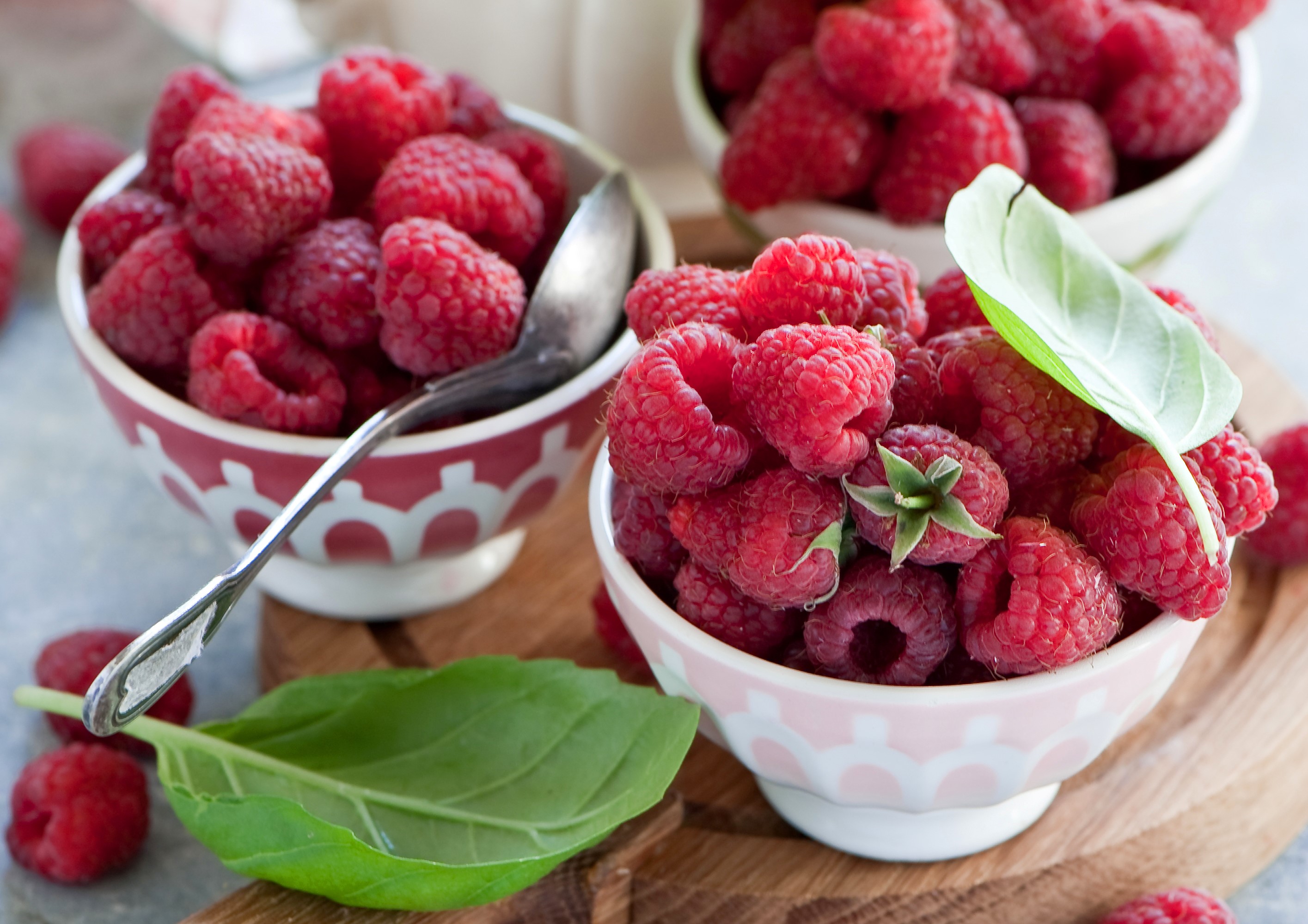 Raspberries in decorative bowls with basil leaves HD Wallpaper