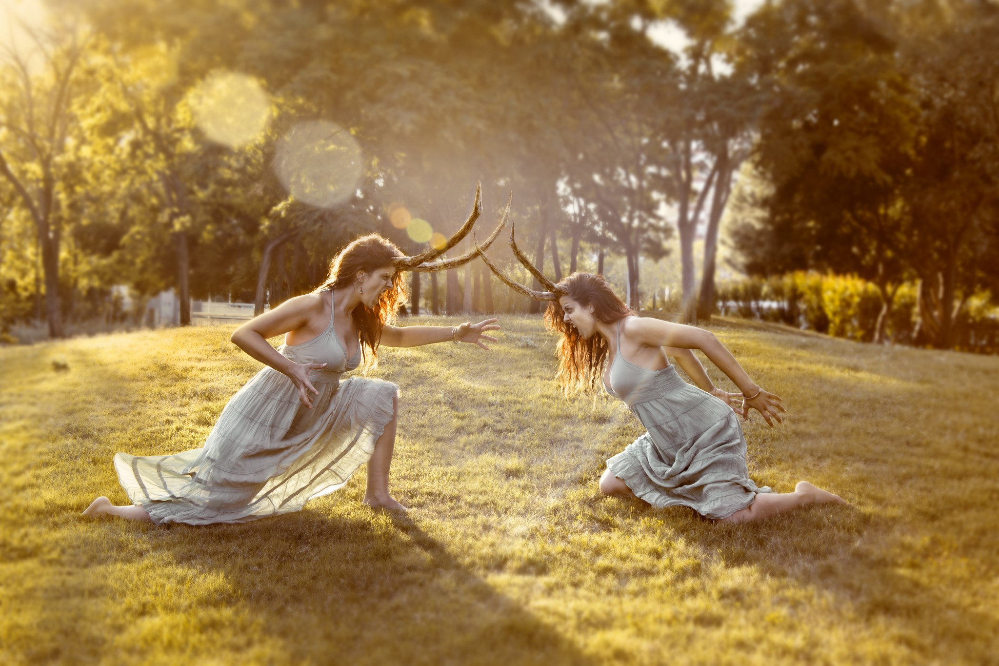 Two women with horns in a grassy field HD Wallpaper