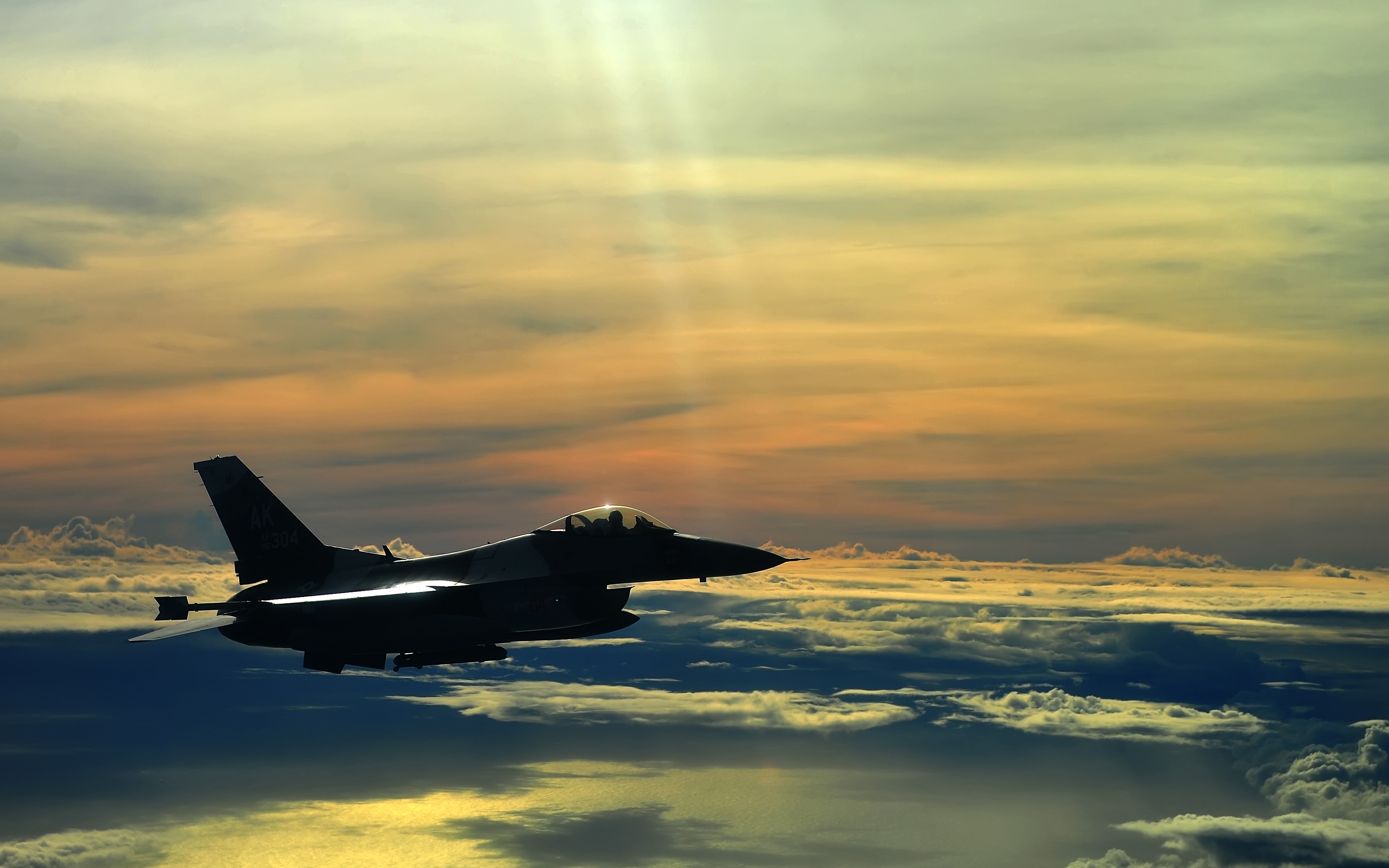 F-16 Fighting Falcon flying through clouds at sunset HD Wallpaper