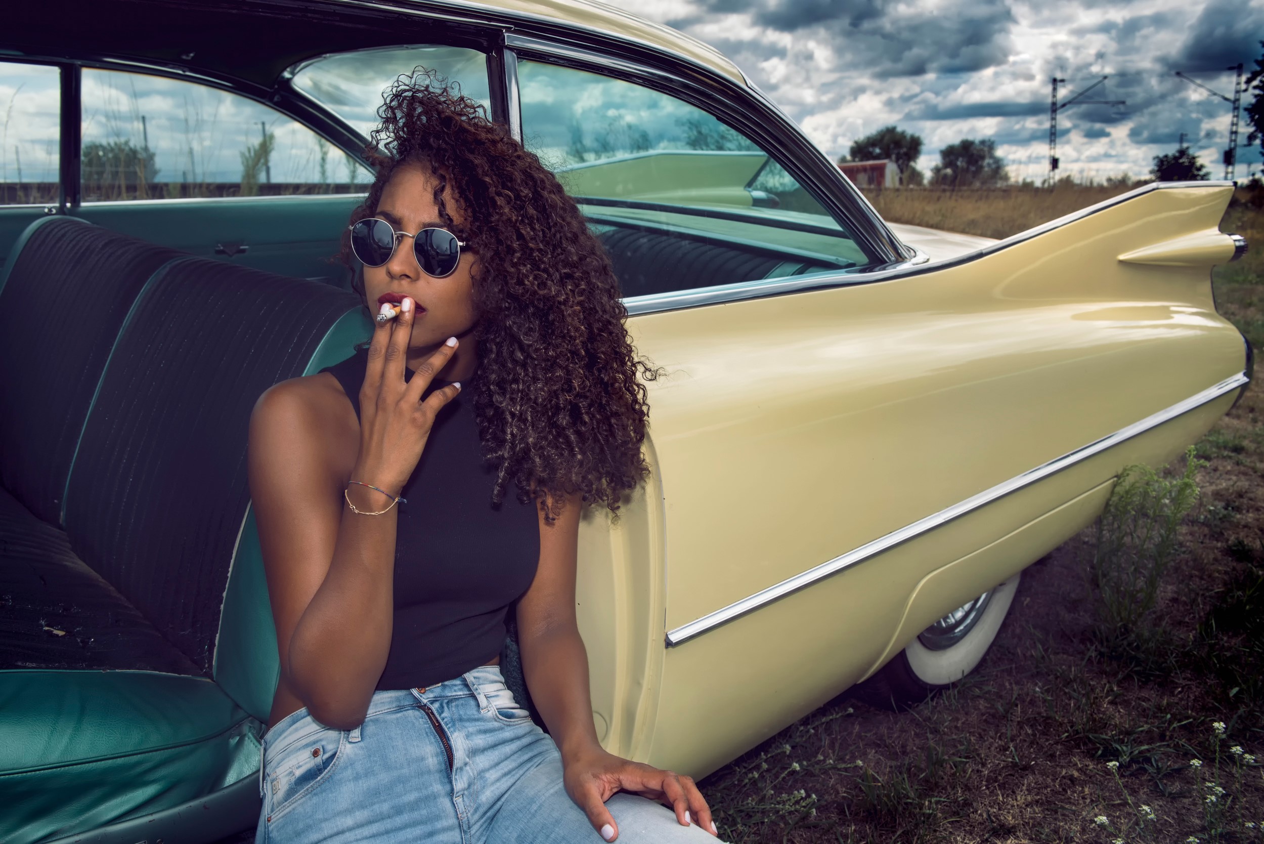 Woman in sunglasses smoking by a vintage car HD Wallpaper