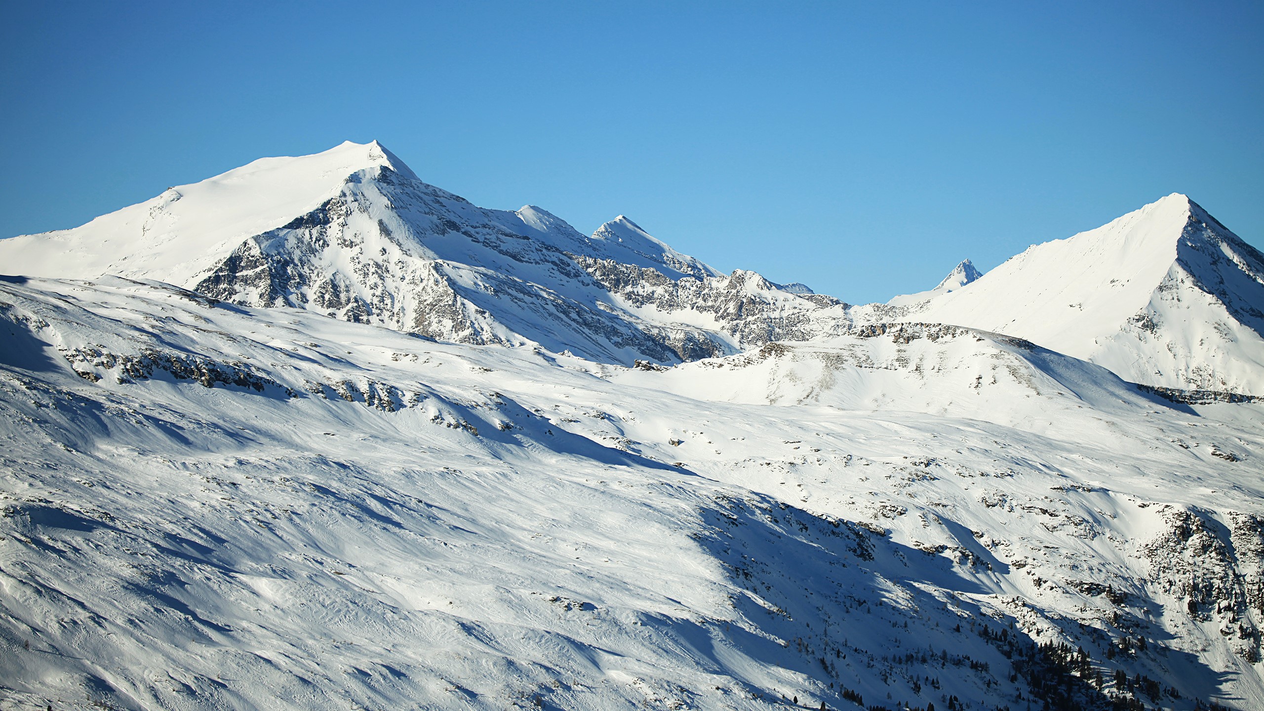 Snow-covered mountains under a clear blue sky HD Wallpaper