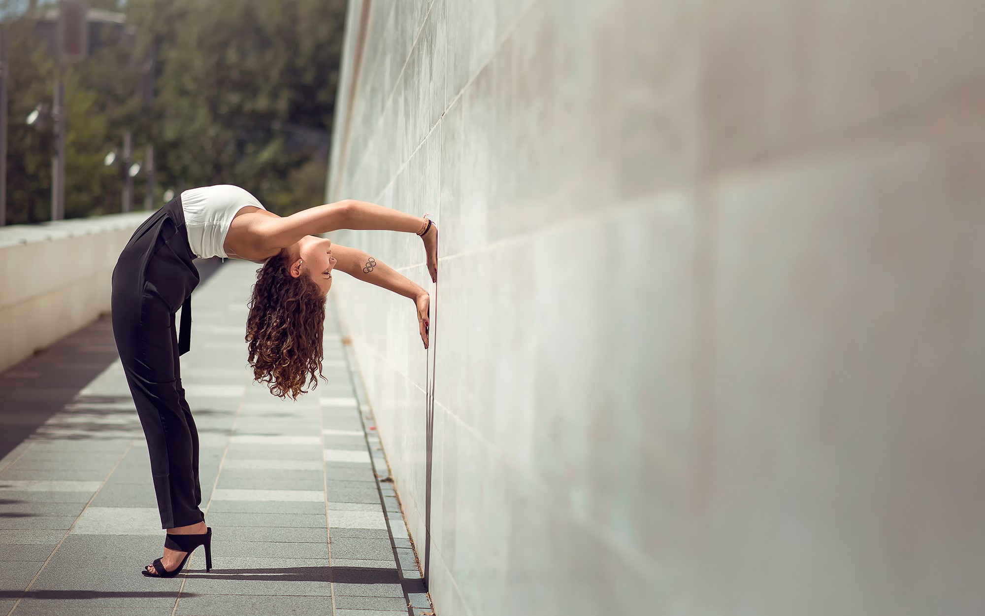 Mira Boumejmajen performing a backbend against a wall HD Wallpaper