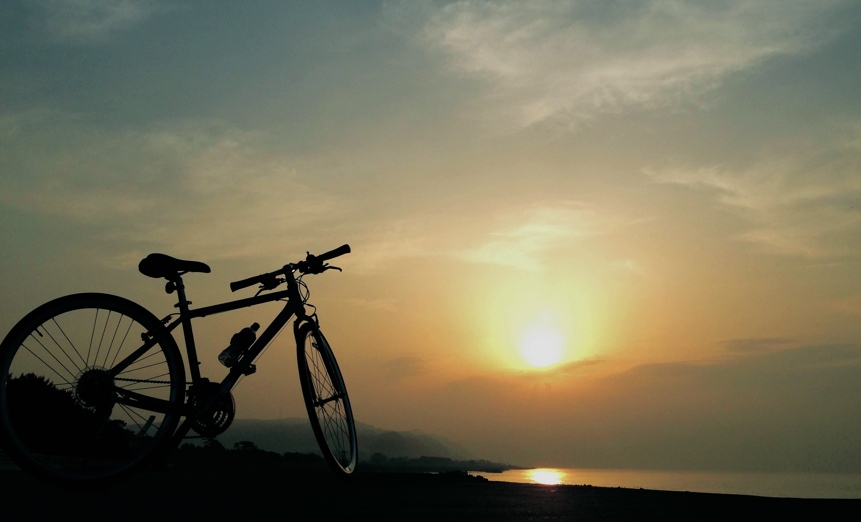 Bicycle silhouette at sunset over the ocean HD Wallpaper