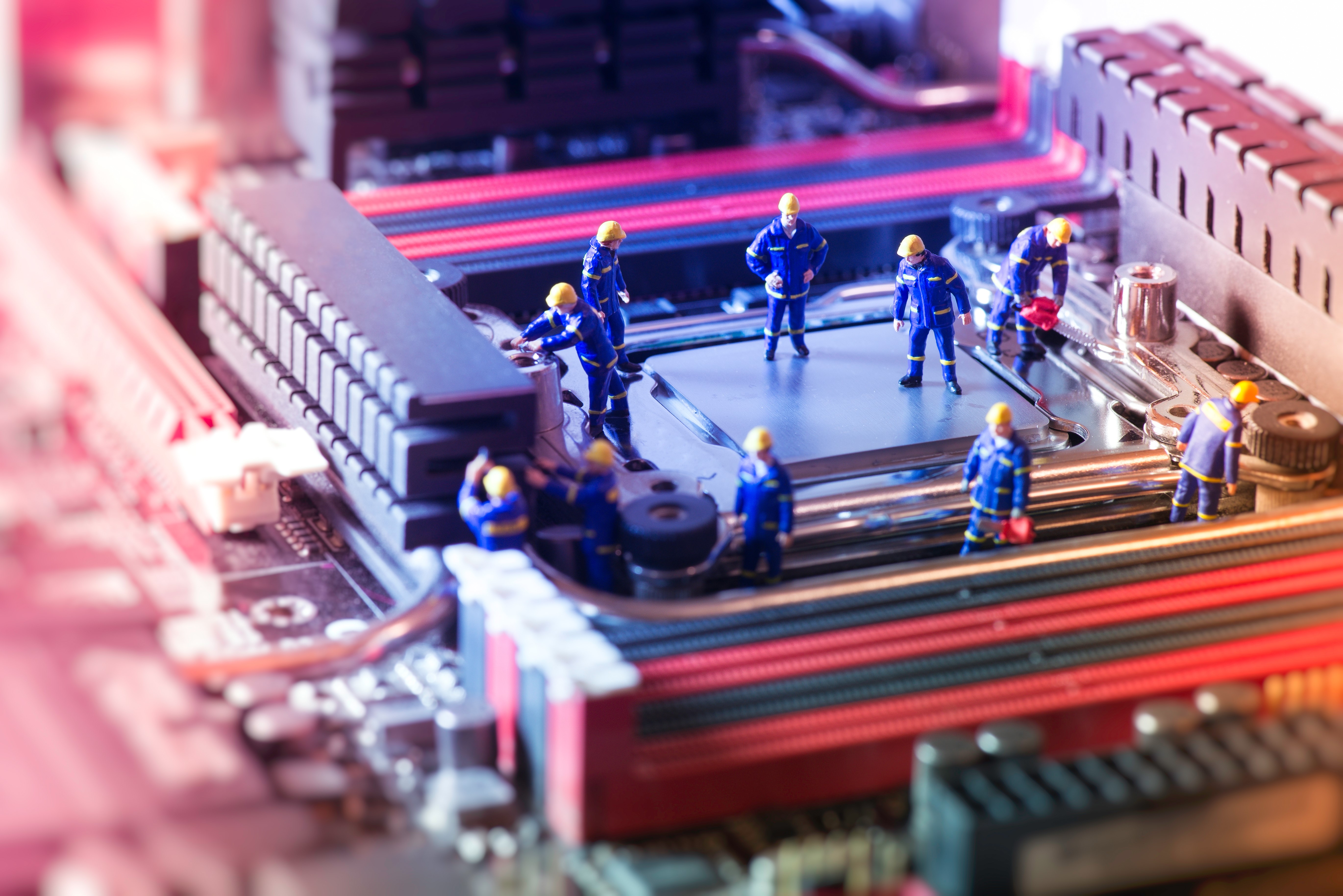 Miniature workers on a computer motherboard HD Wallpaper