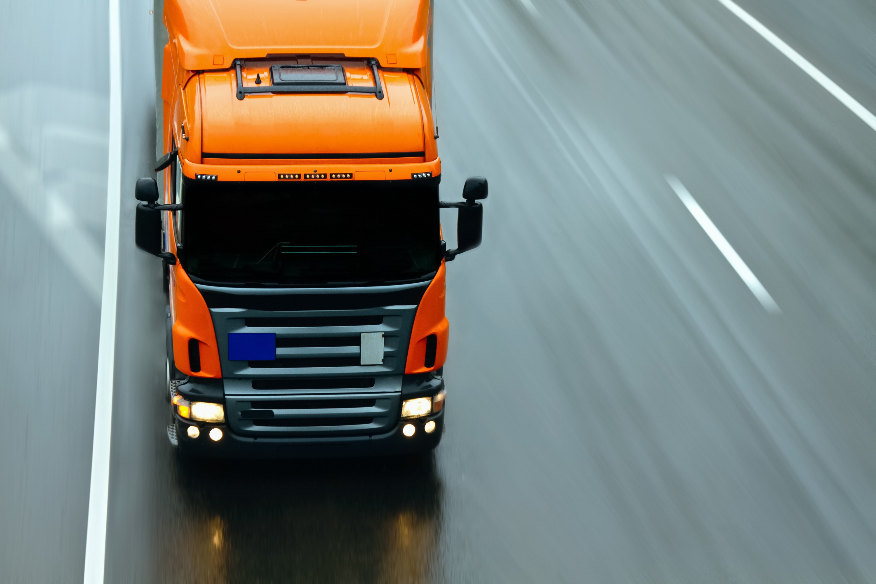 Orange truck driving on a wet highway HD Wallpaper