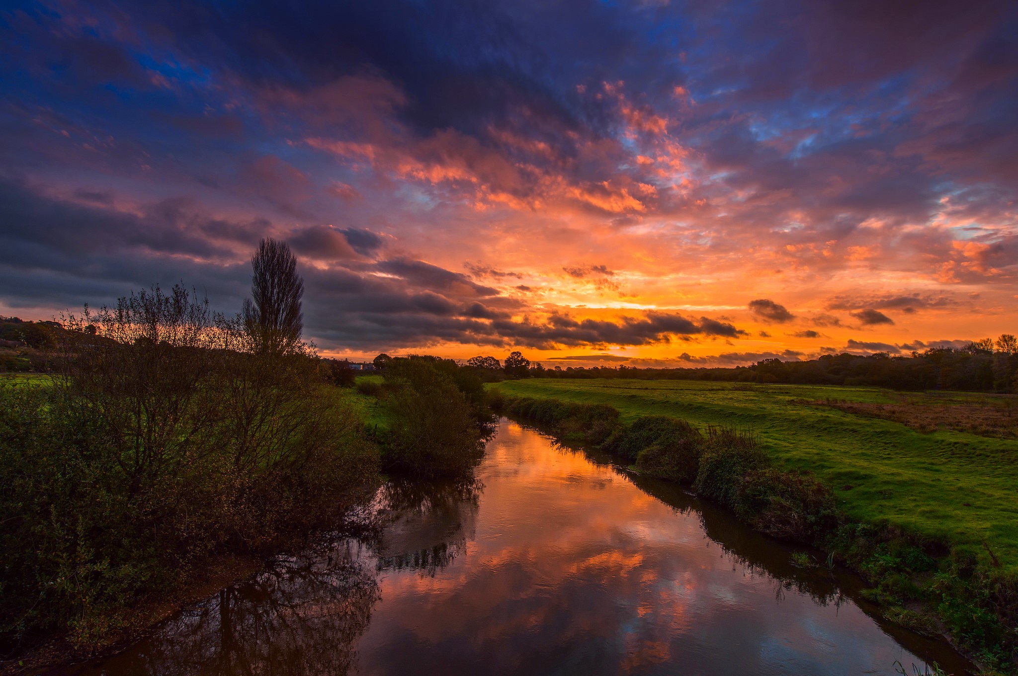River reflecting a vibrant sunset with dramatic clouds HD Wallpaper