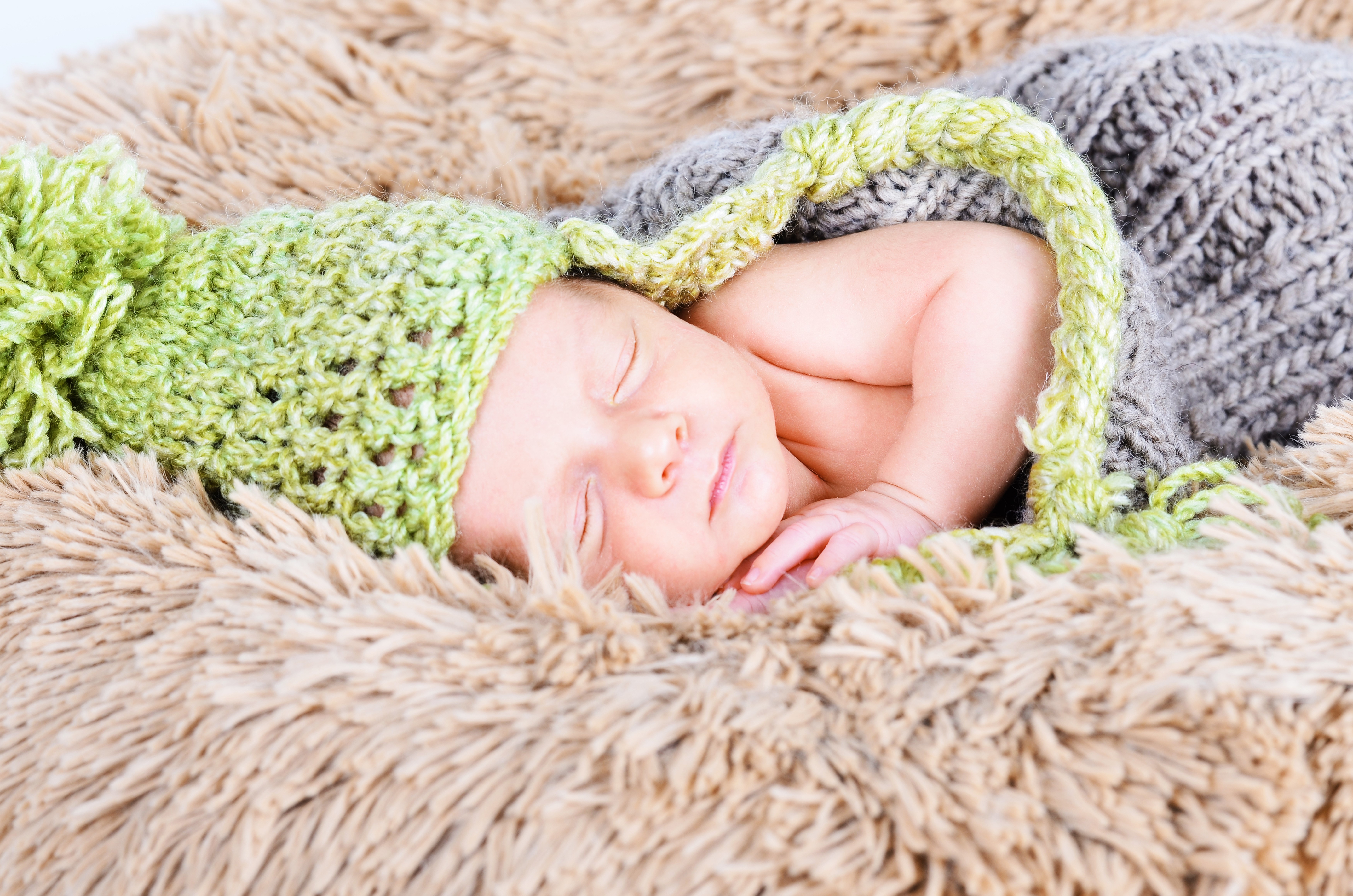 Newborn baby sleeping in a knitted hat HD Wallpaper