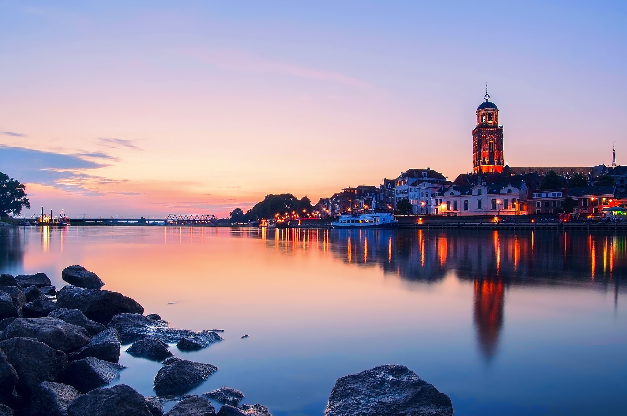 Cityscape with river and church tower at sunset HD Wallpaper