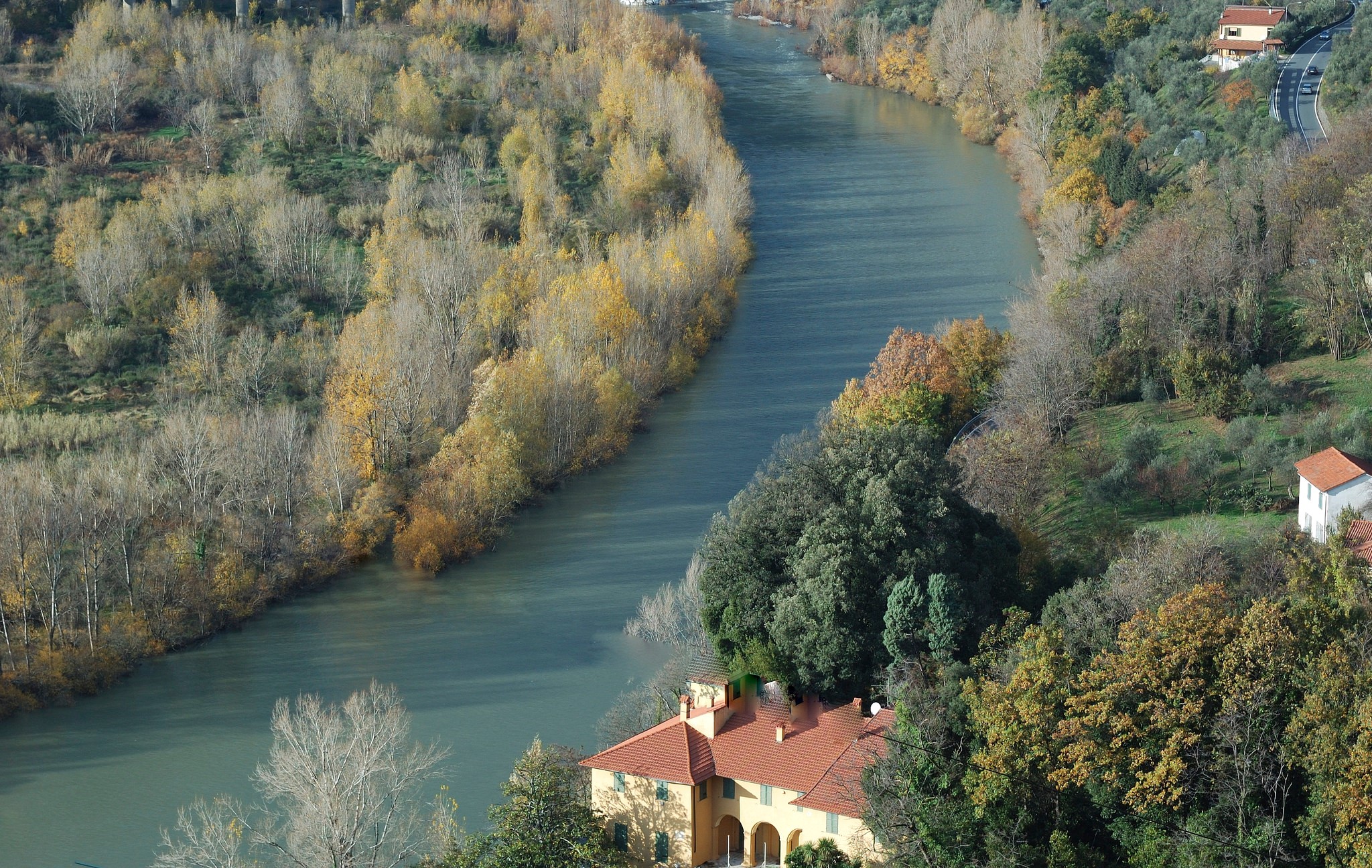 River flowing through a forest with houses on the hill HD Wallpaper