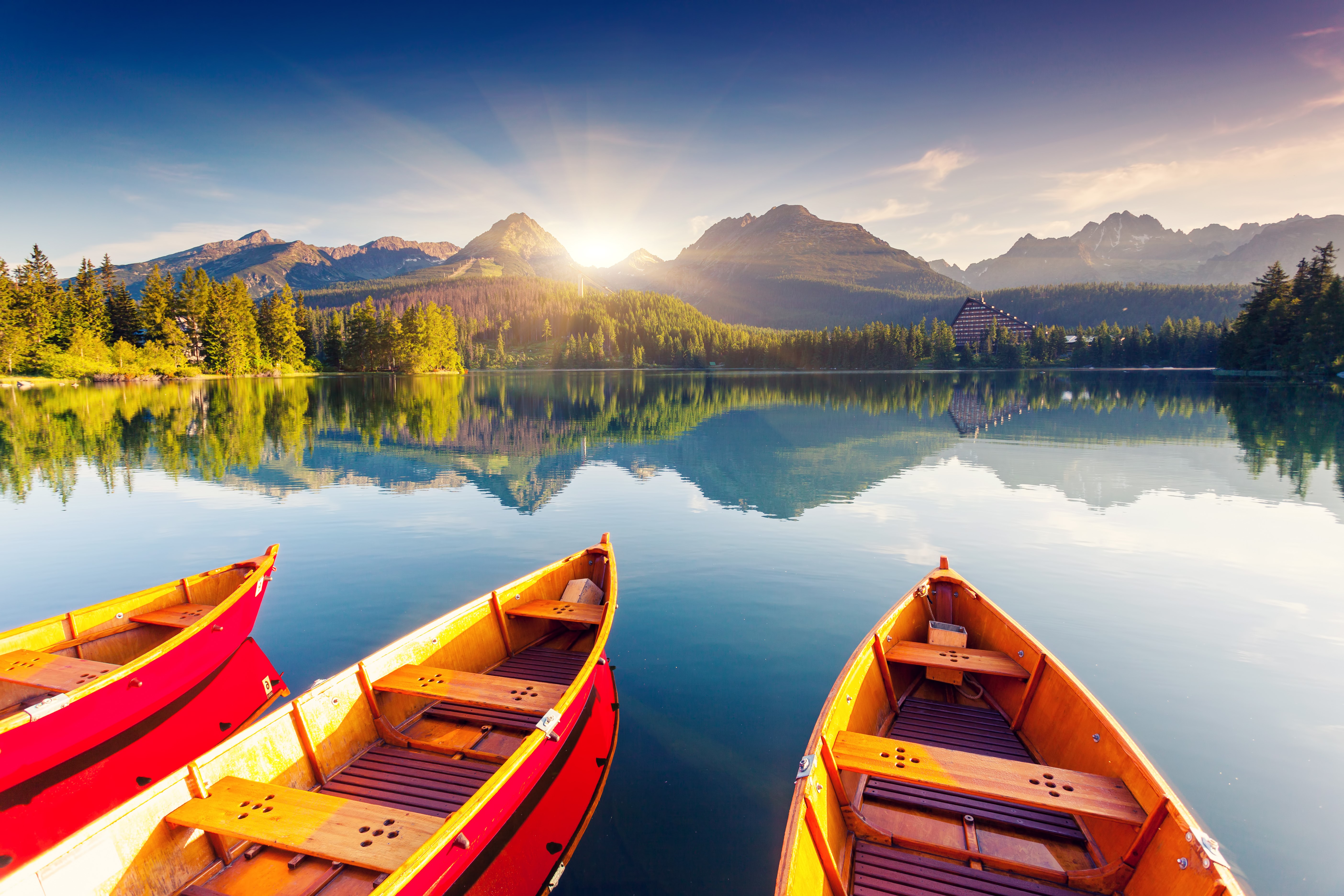 Boats on a lake with mountains at sunrise HD Wallpaper