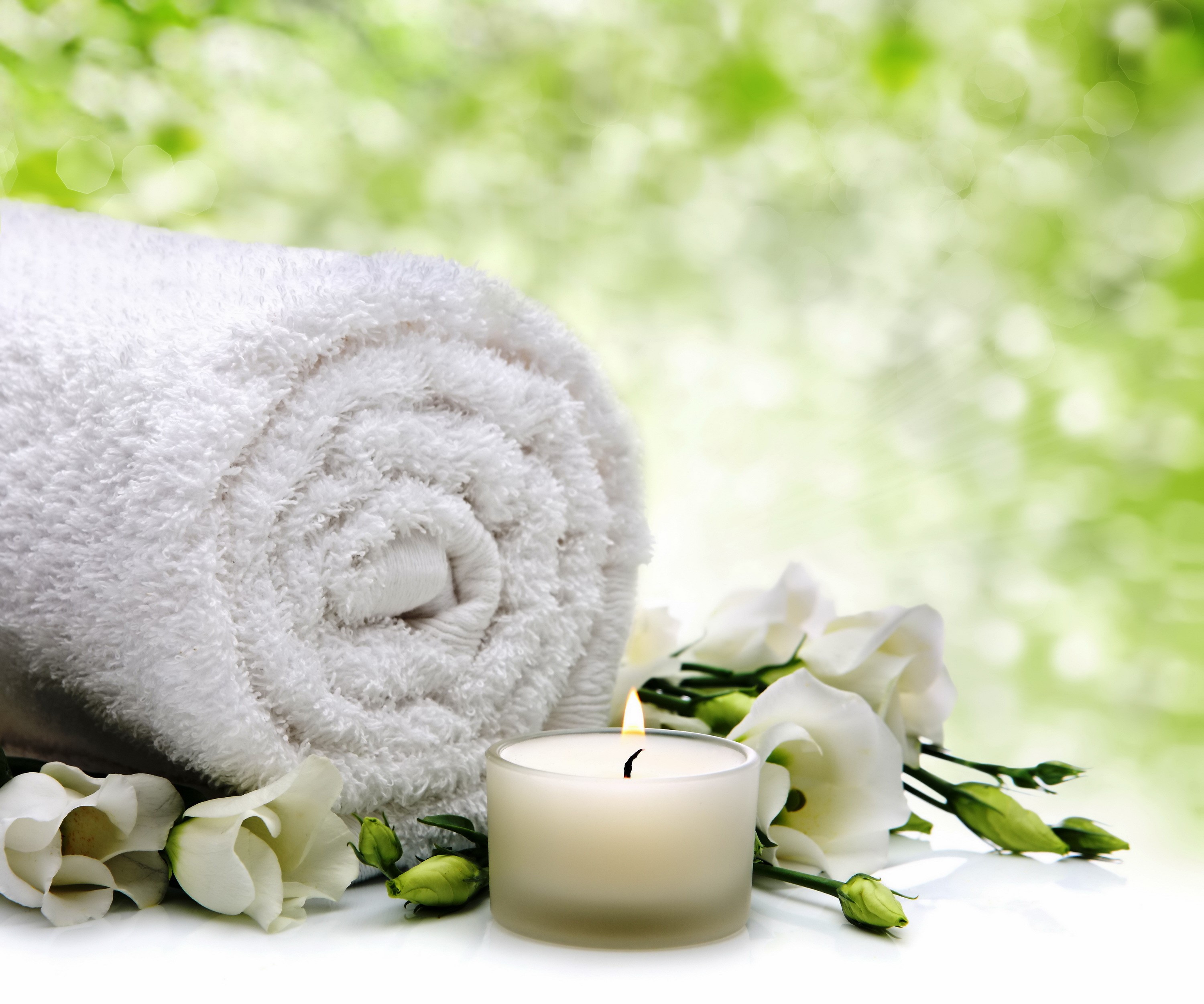 Rolled towel with white flowers and candle HD Wallpaper