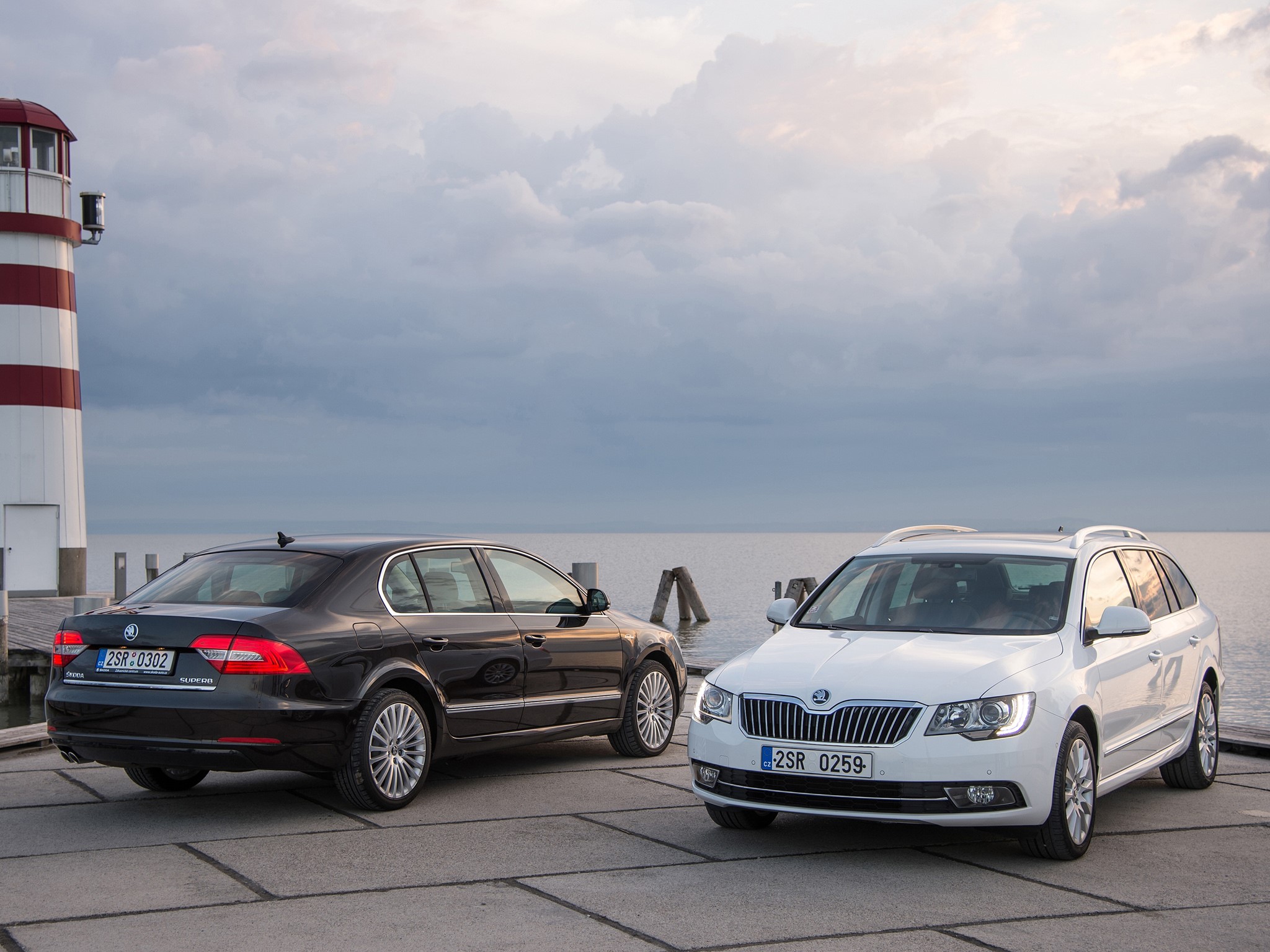 Two Skoda Superb cars by a lighthouse HD Wallpaper