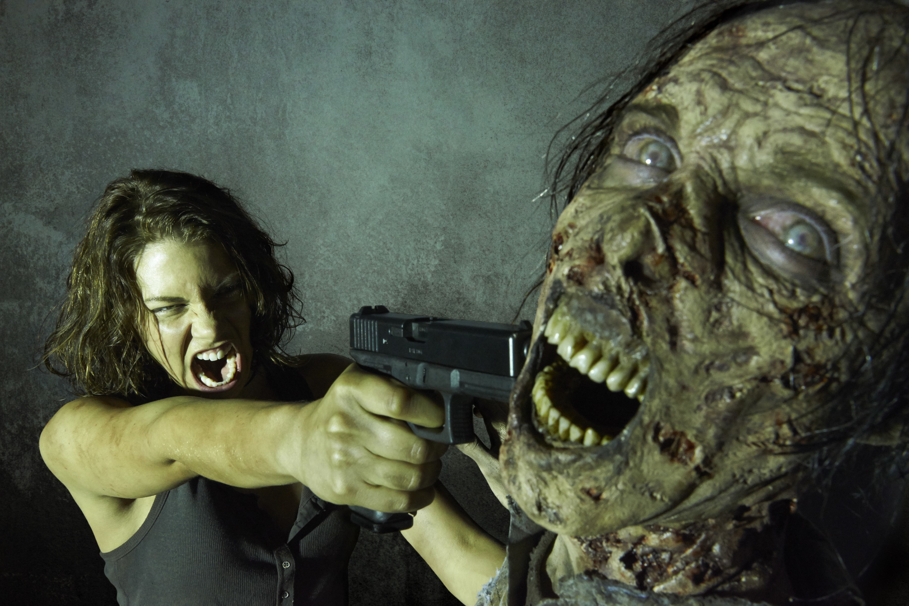 Maggie from The Walking Dead aims a pistol at a zombie HD Wallpaper
