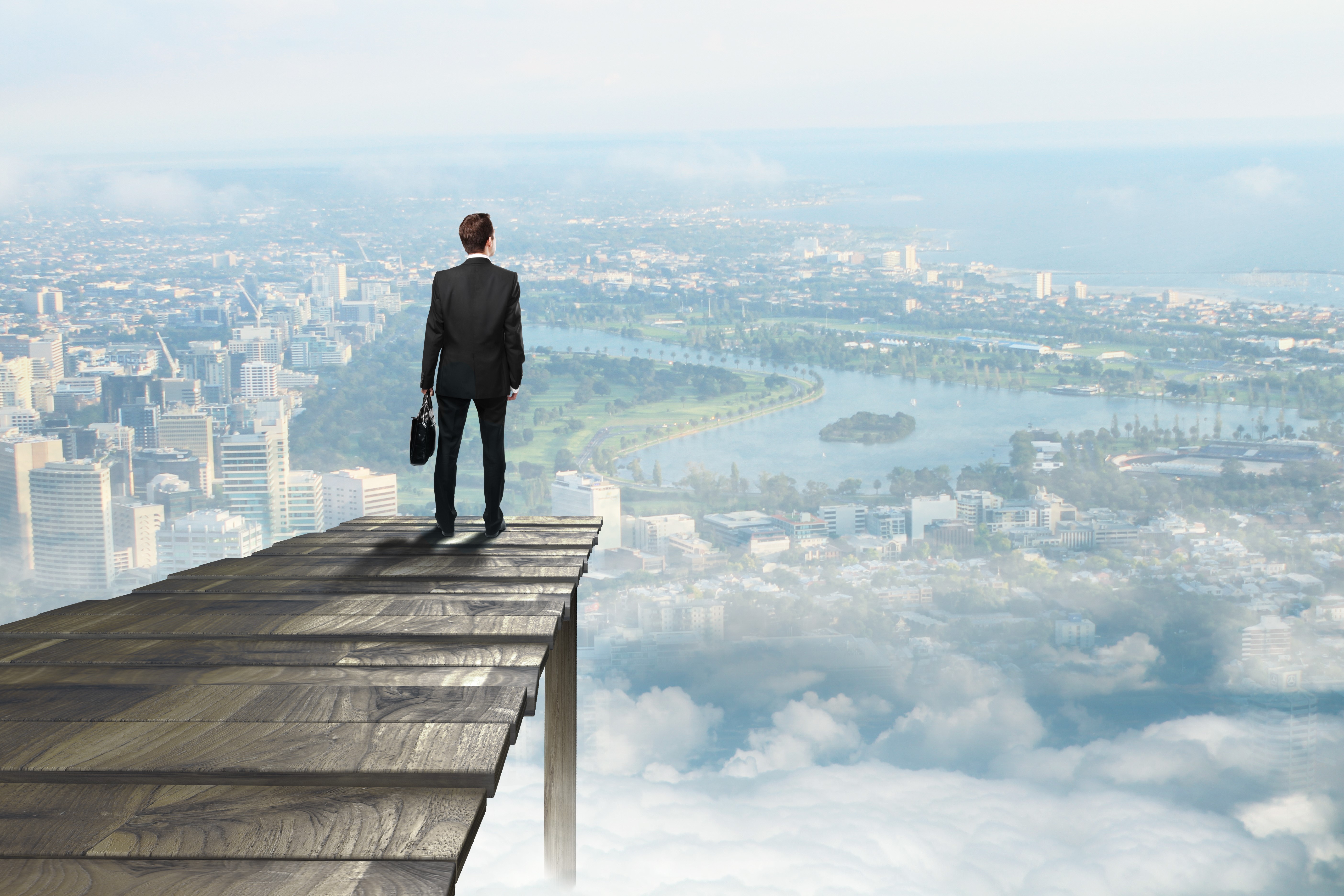 Man in suit on wooden platform overlooking city HD Wallpaper