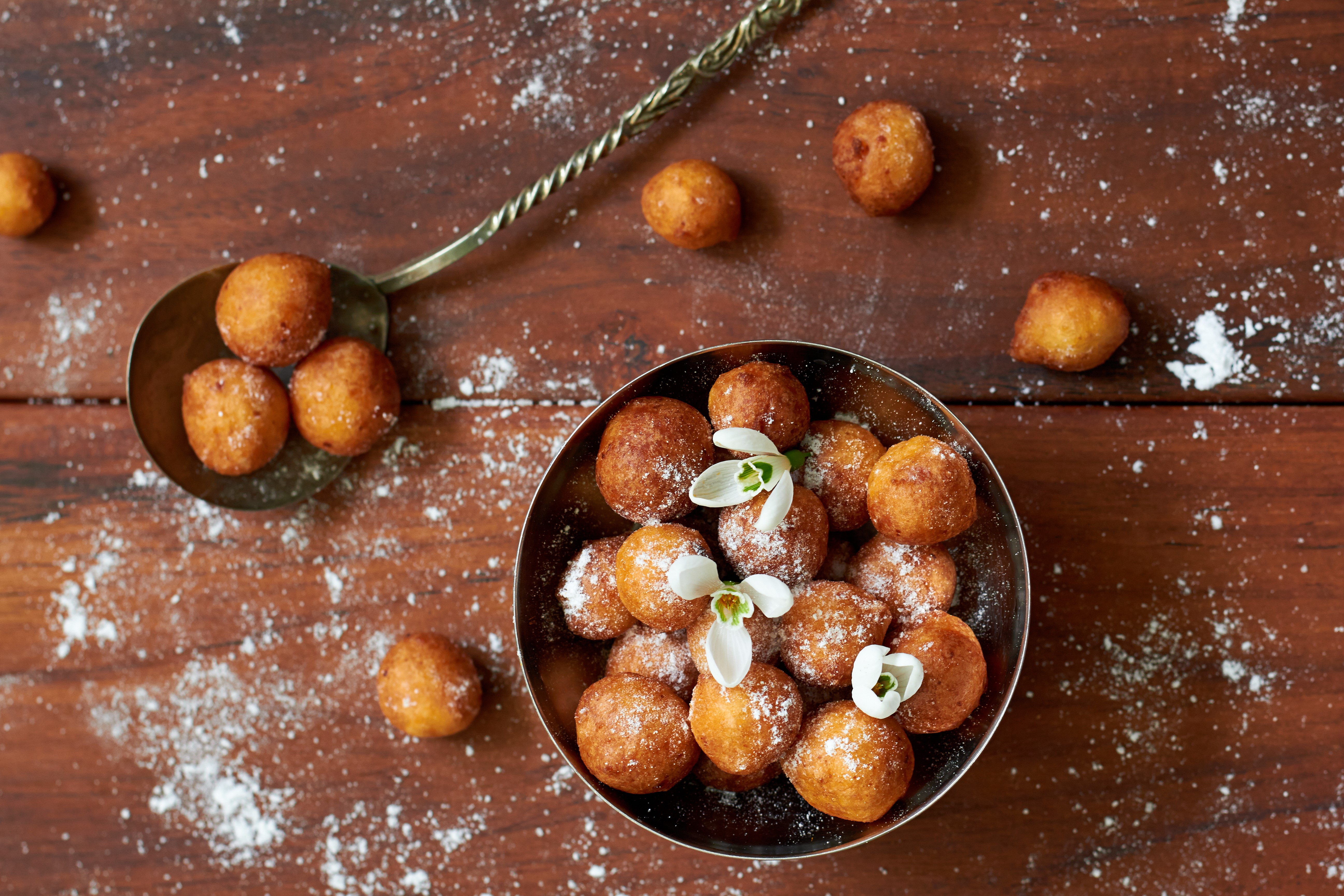 Fried pastries with powdered sugar and flowers HD Wallpaper