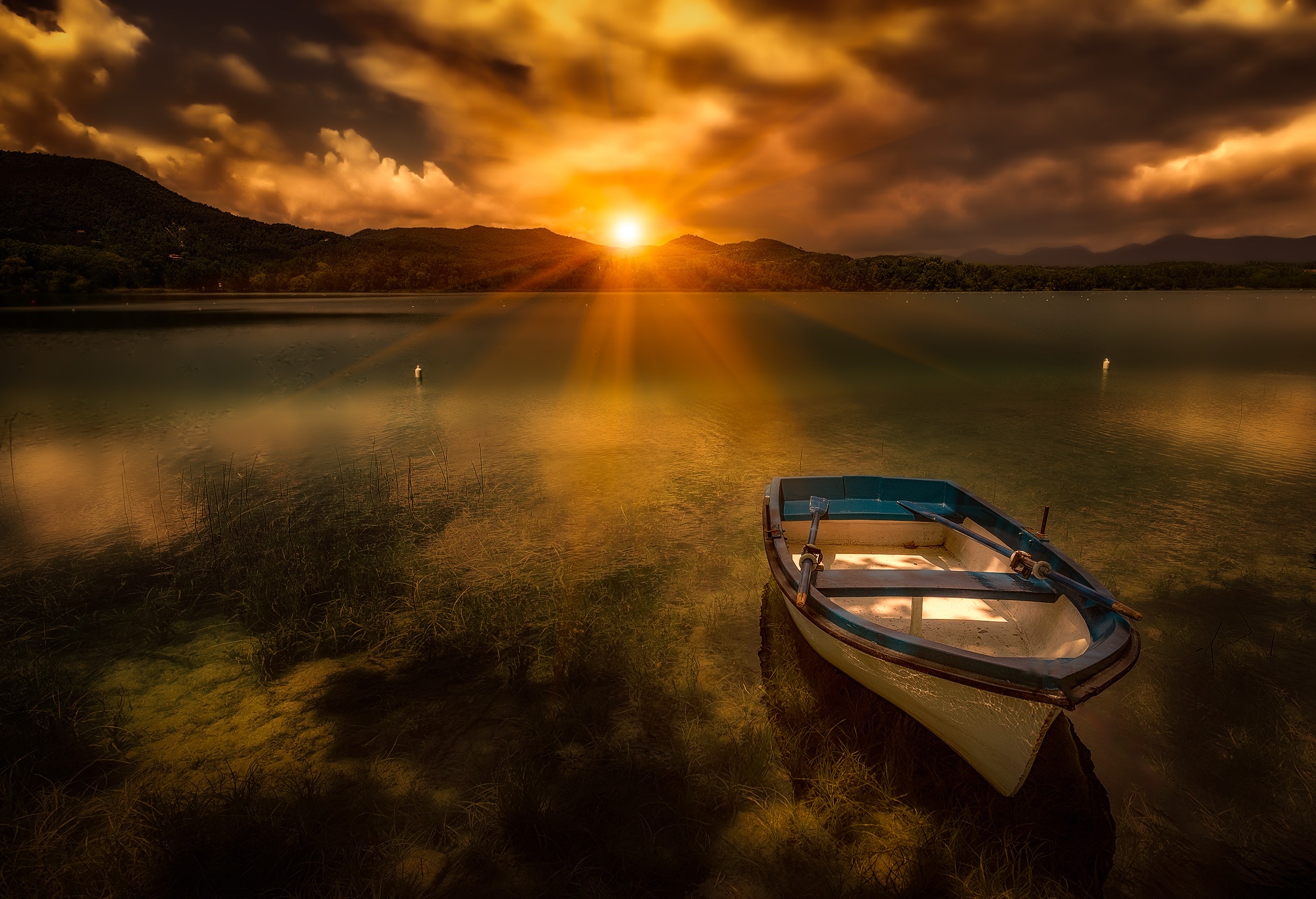 Boat on Lake Banyoles at sunset with sun rays HD Wallpaper