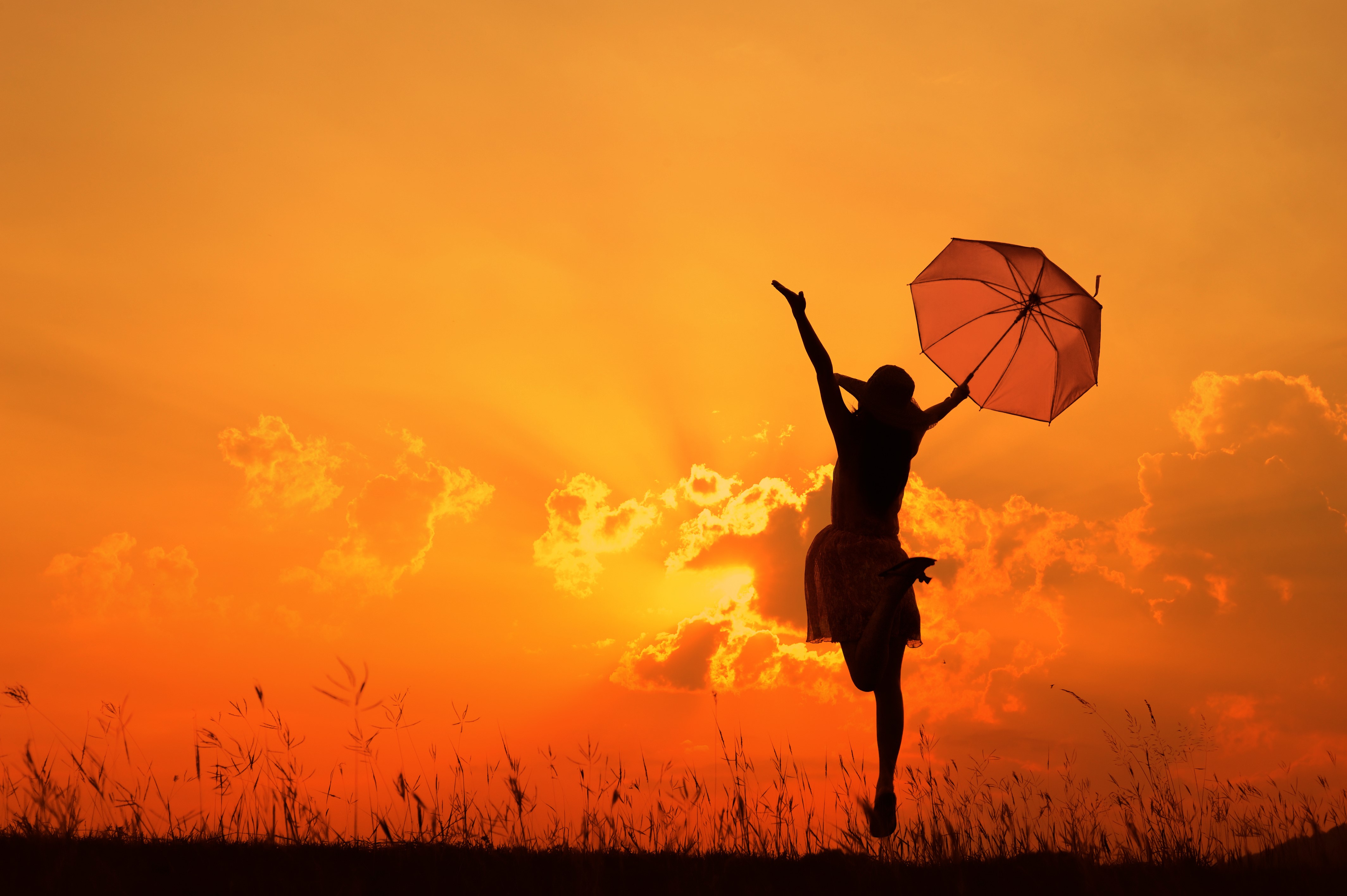 Silhouette of a person with an umbrella at sunset HD Wallpaper