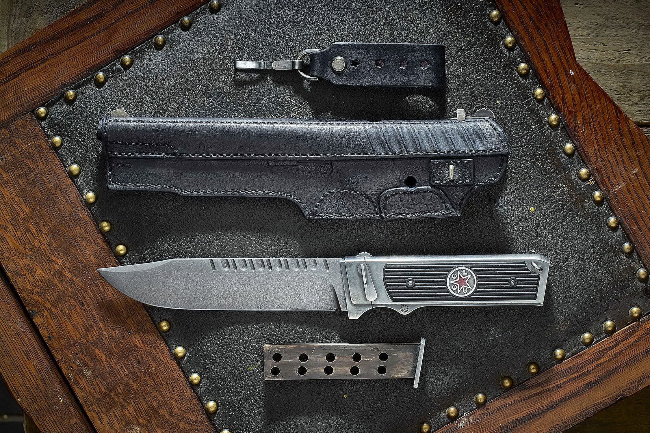 Knife and gun holster on a studded surface HD Wallpaper