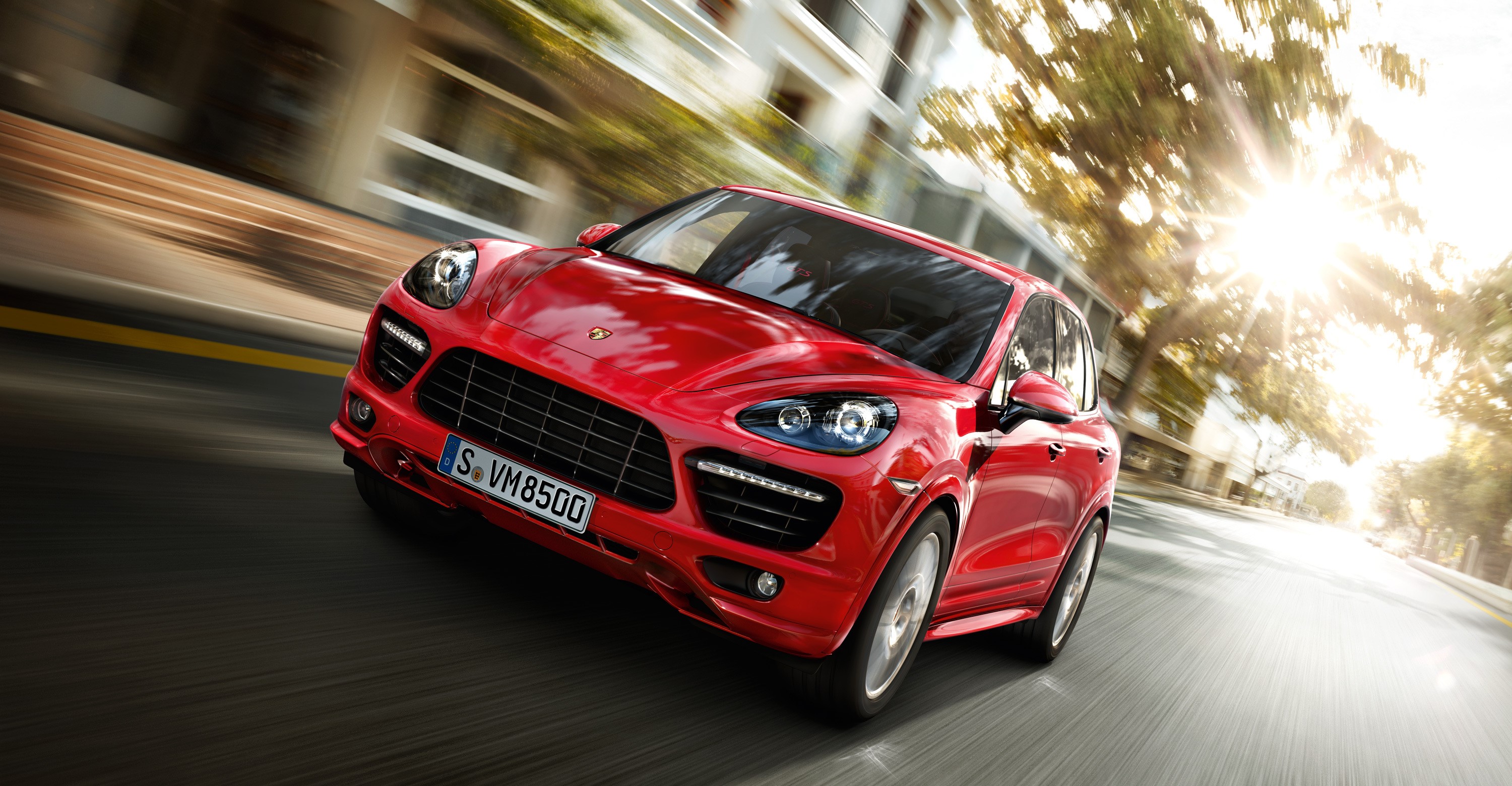 Red Porsche Cayenne driving on a street HD Wallpaper