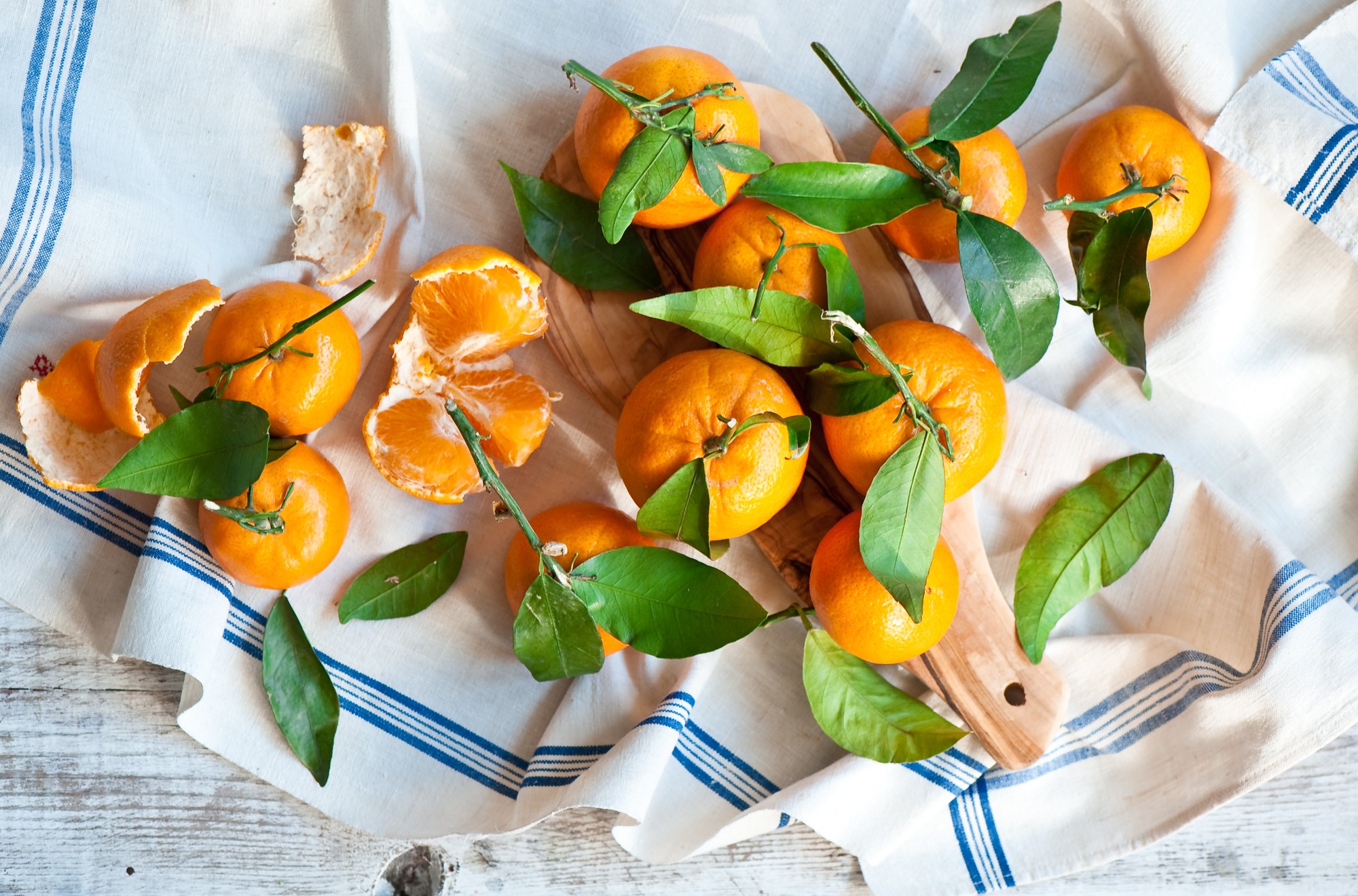 Tangerines with leaves on a striped cloth HD Wallpaper