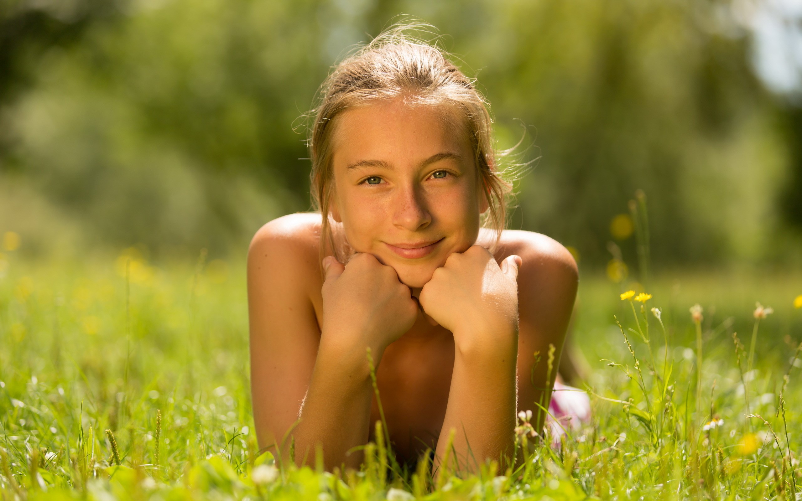 Young girl lying in grass on a sunny day HD Wallpaper