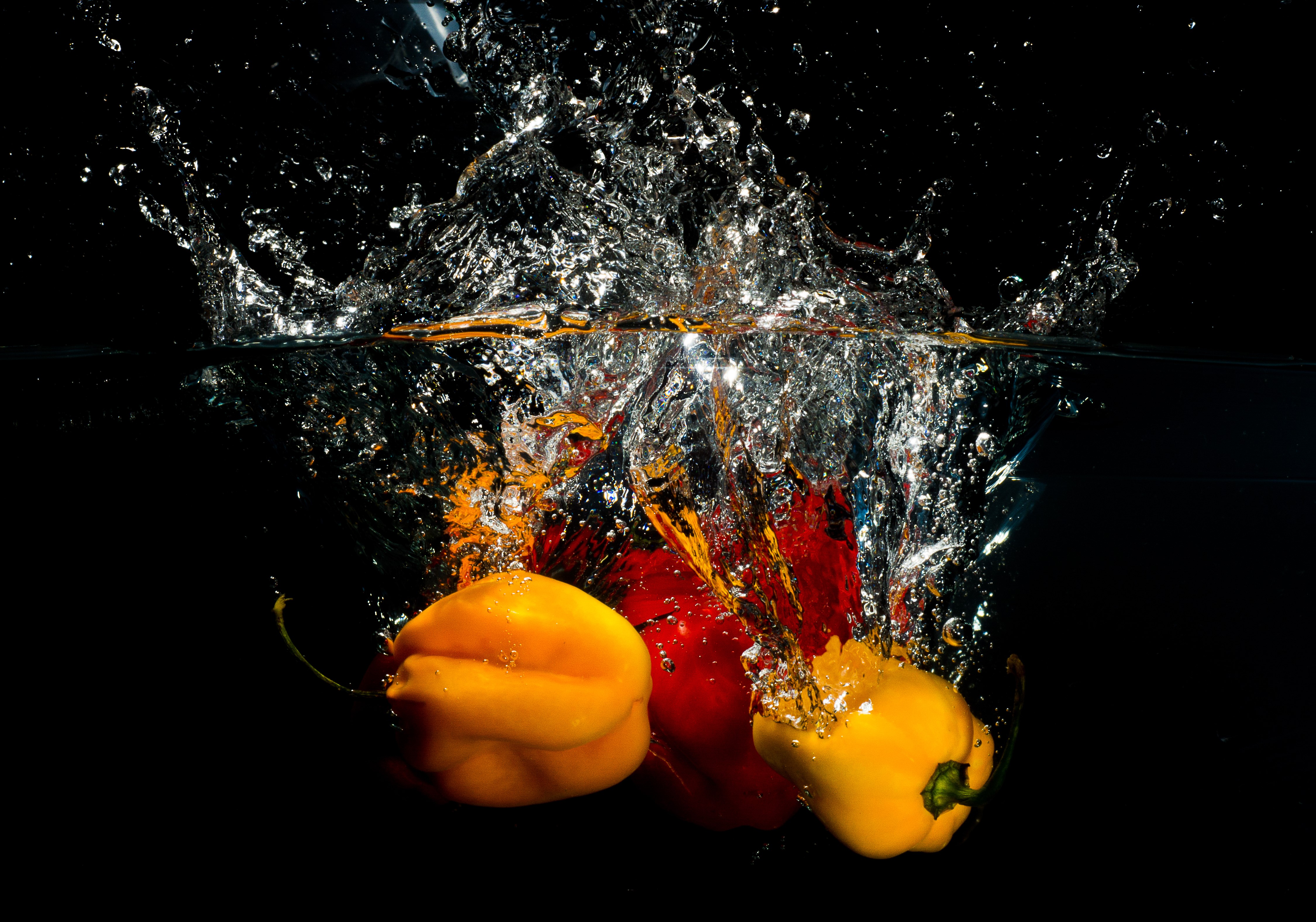 Bell peppers splashing into water HD Wallpaper