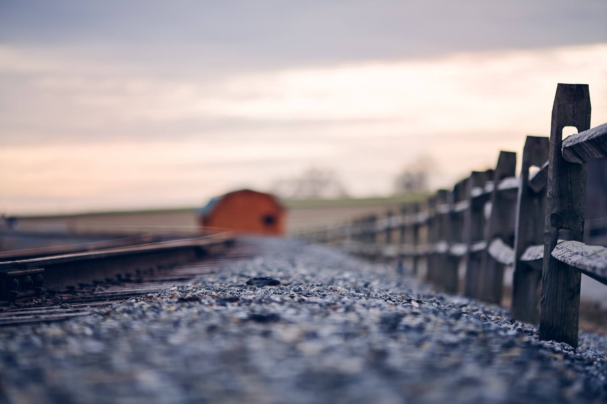 Railroad tracks and wooden fence in rural landscape HD Wallpaper