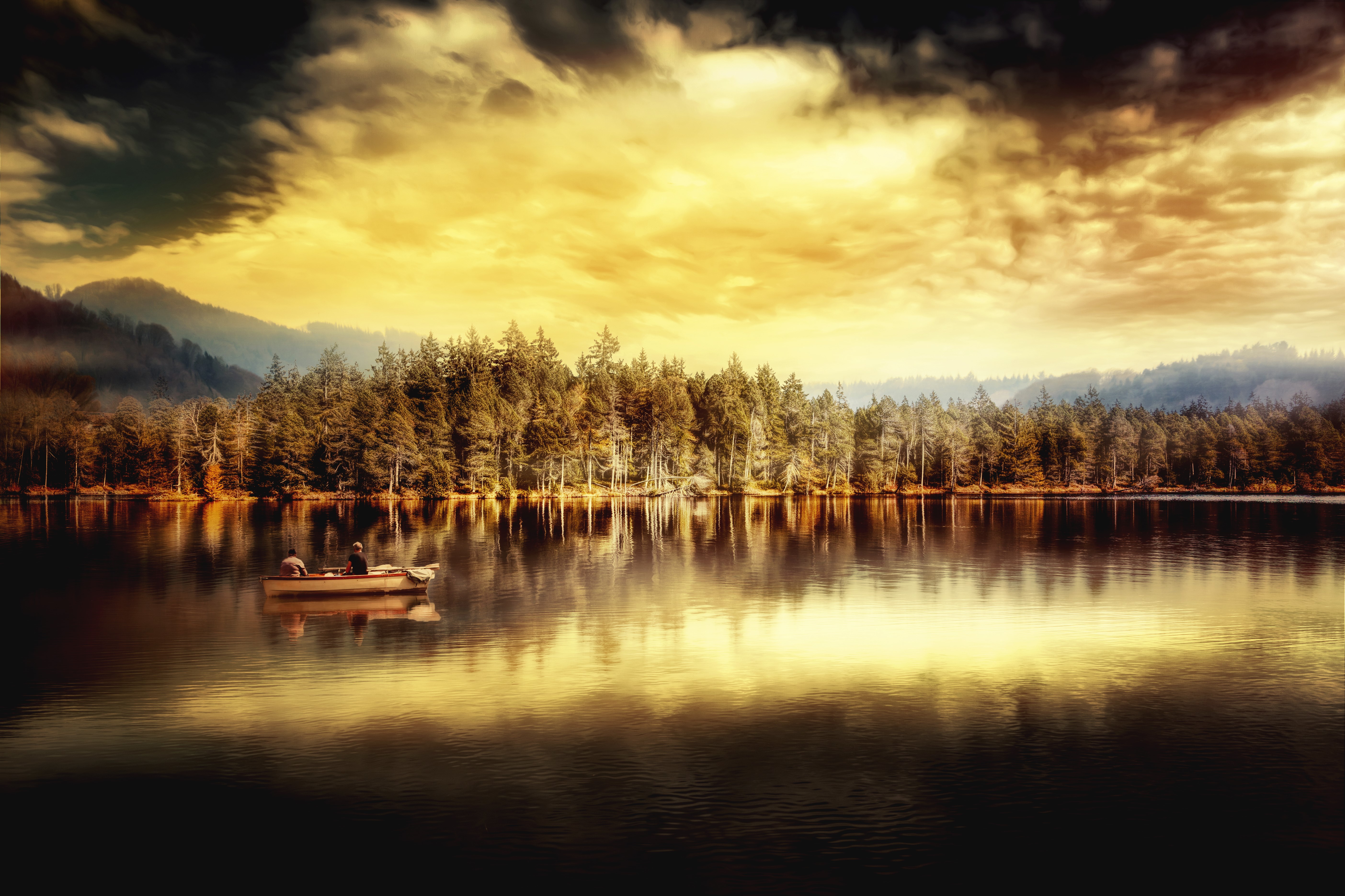Two people in a boat on a lake with a forest and mountains HD Wallpaper