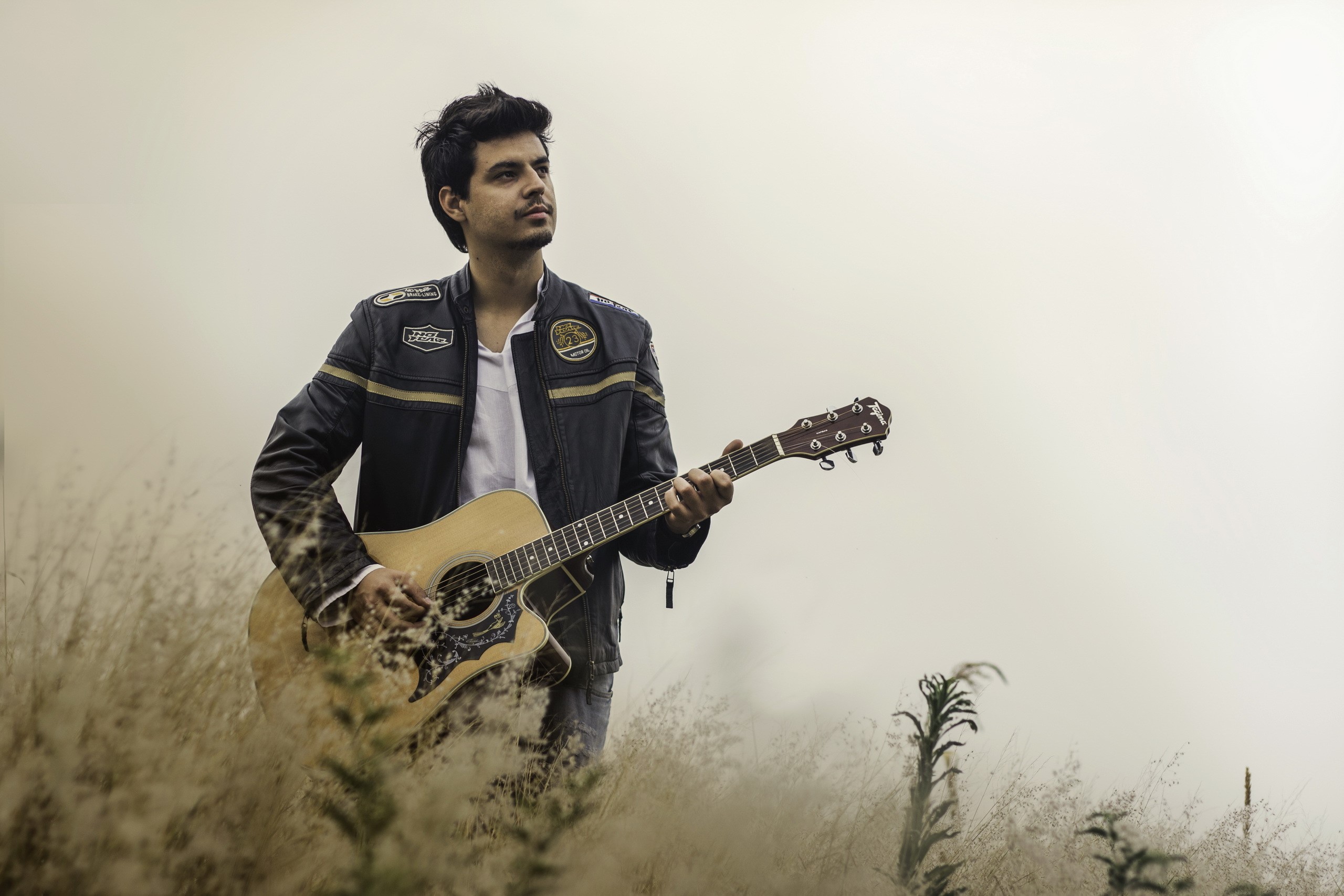 Man playing guitar in foggy field HD Wallpaper