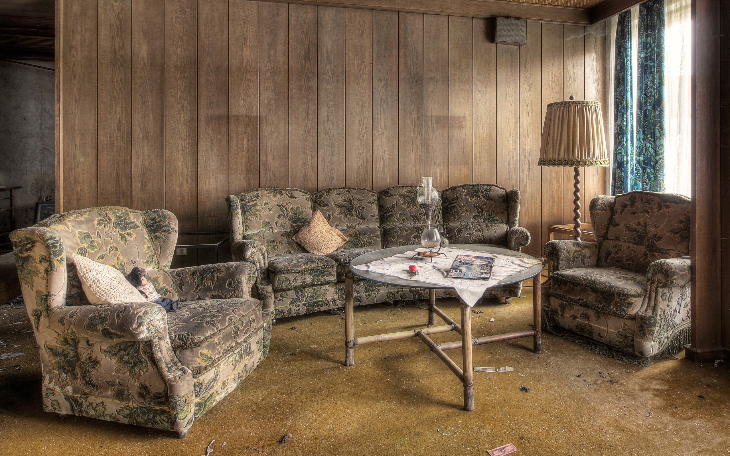 Abandoned living room with floral furniture and wood paneling HD Wallpaper