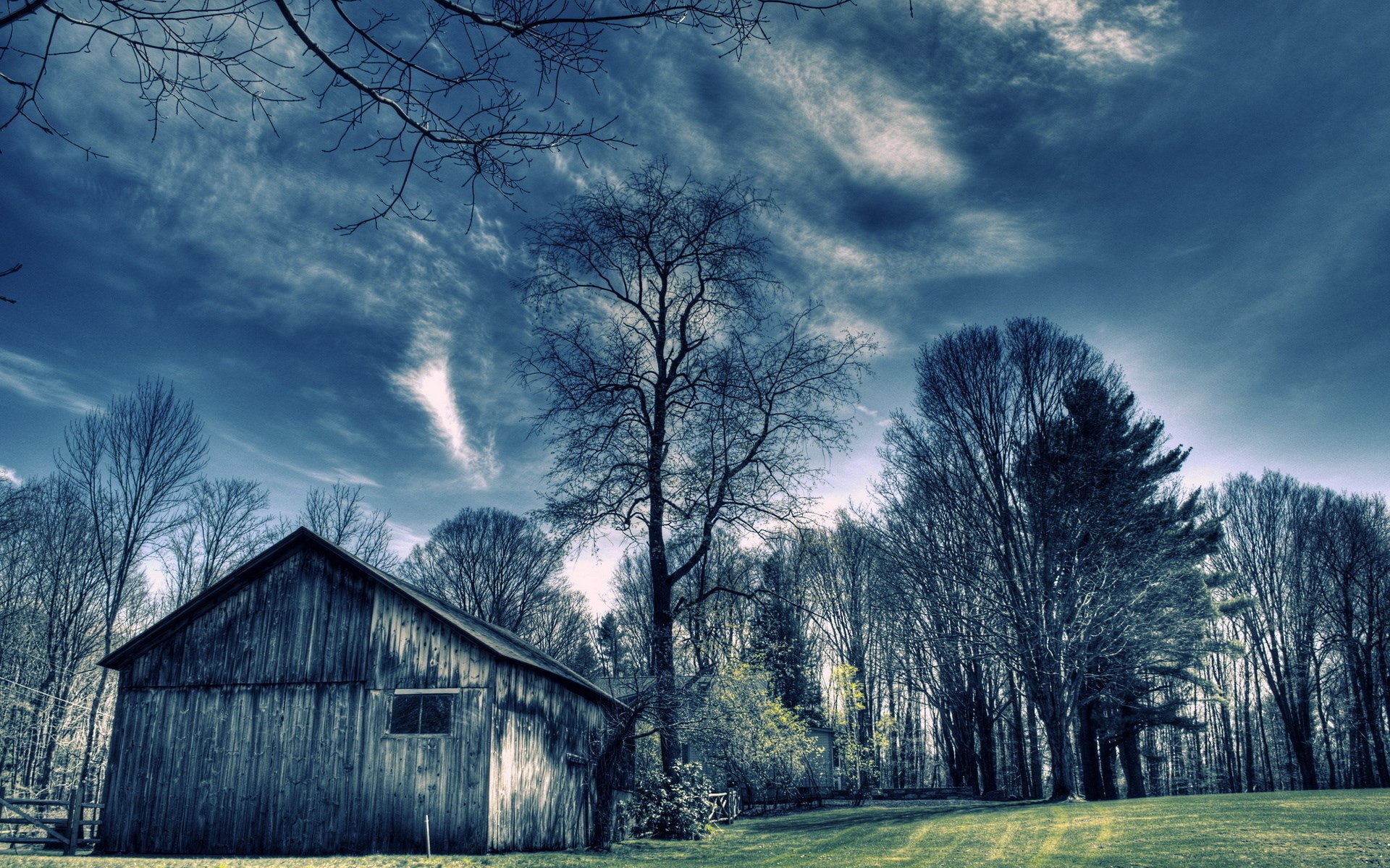 Old wooden barn and bare trees under a cloudy sky HD Wallpaper