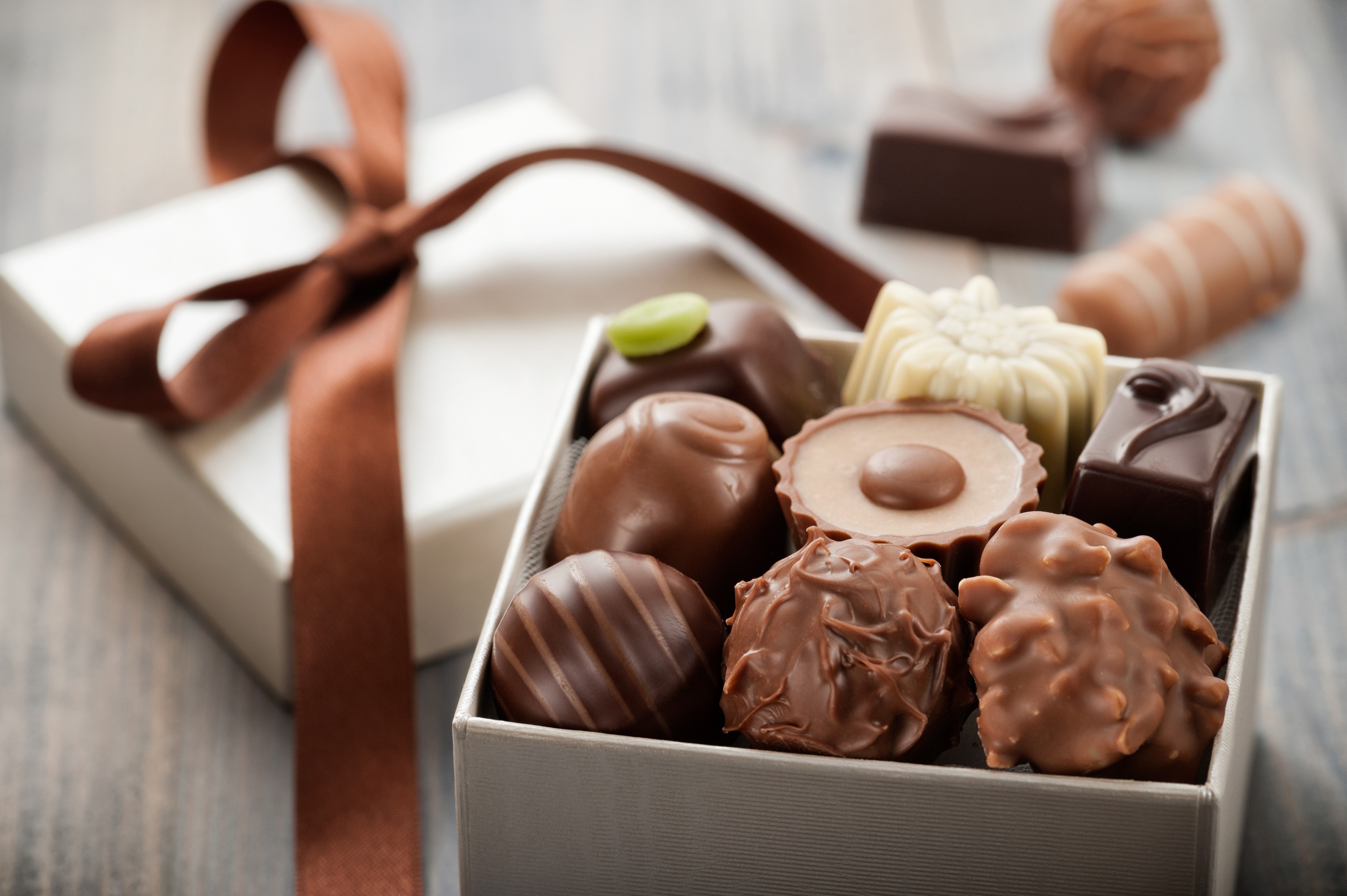 Box of assorted chocolates with a ribbon HD Wallpaper