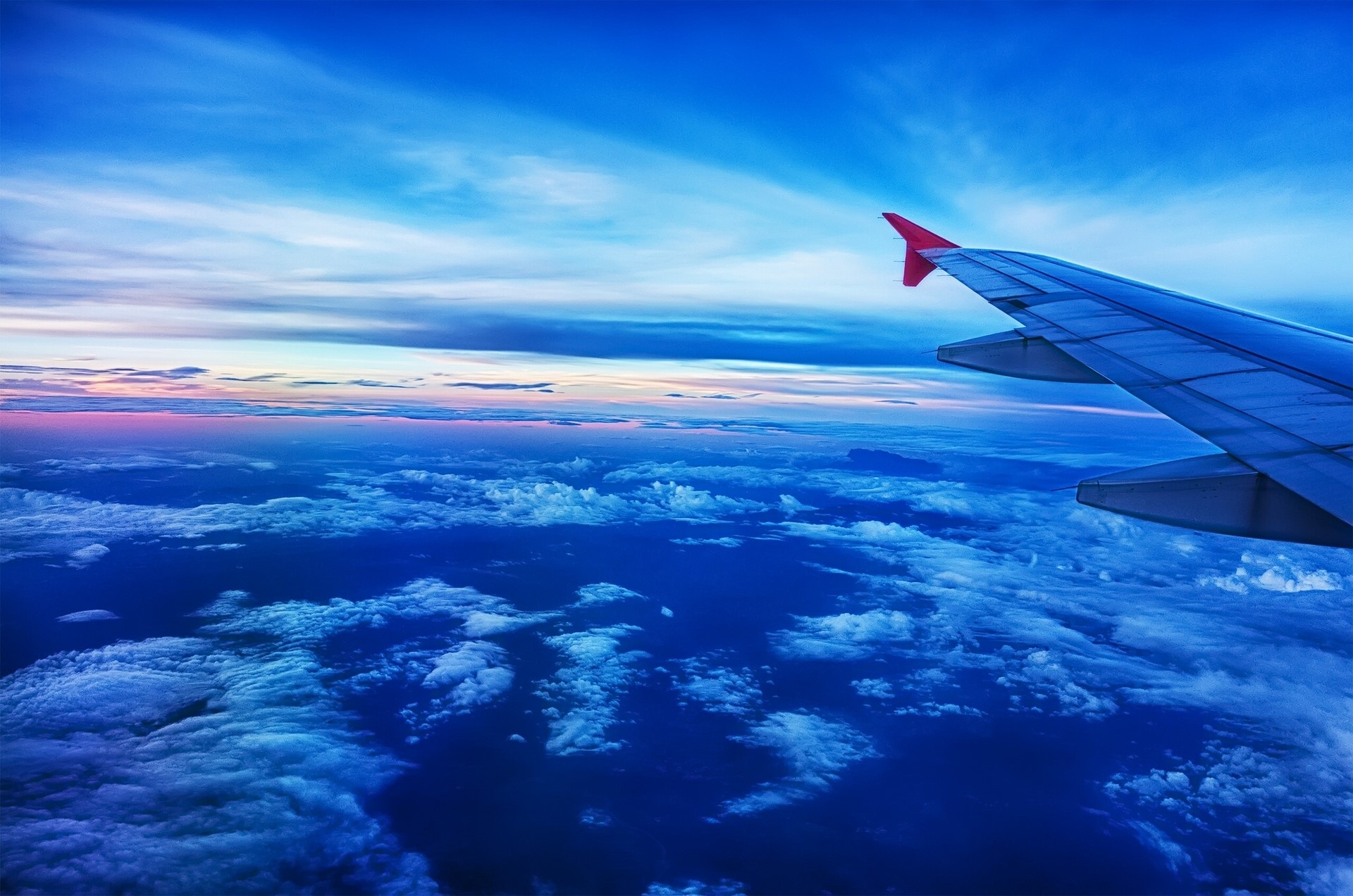 Airplane wing over clouds at sunset HD Wallpaper