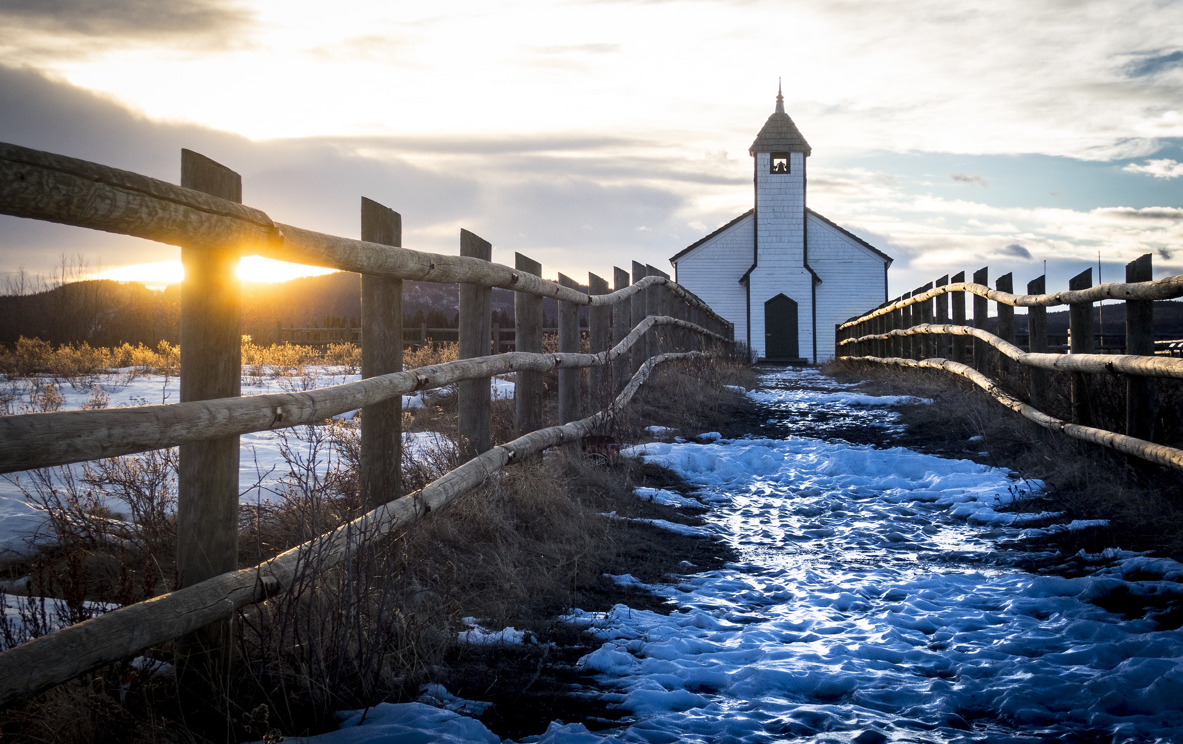 White church with bell tower and wooden fence in winter HD Wallpaper